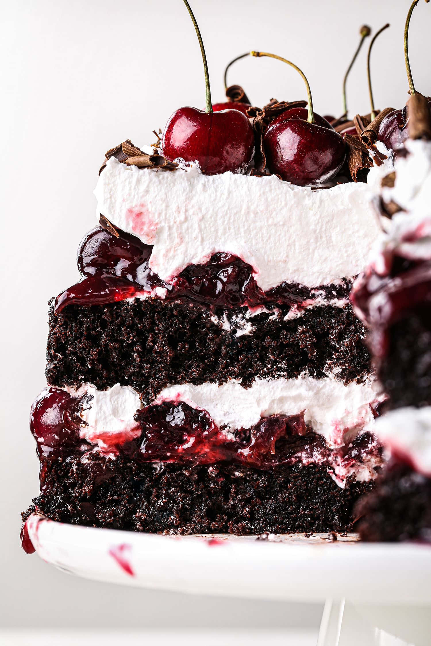 Black Forest Cake 桌布 壁紙 — 一塊頹廢的黑櫻桃蛋糕，帶有濃郁的巧克力層和光亮的櫻桃配料。