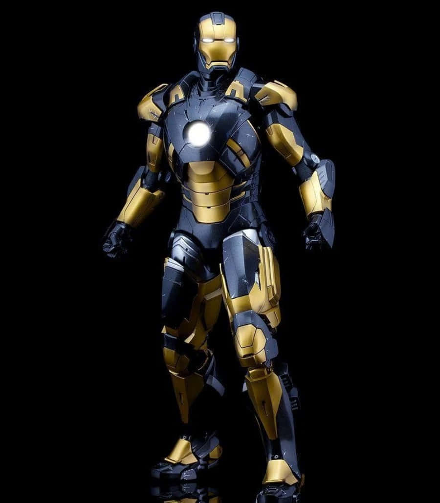 Vibranium Suit 桌布 壁紙 — 一套金色和黑色的全身鐵甲奇俠裝甲，在純黑色背景上擺出姿勢，電弧反應器和眼睛發光。
