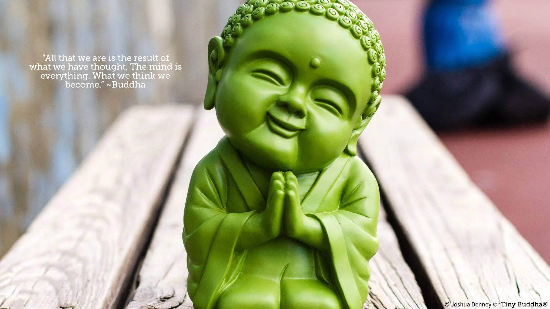 勵志語錄 桌布 壁紙 — 一尊亮綠色佛像，閉著眼睛，雙手合十，平靜地坐在風化的木板上。