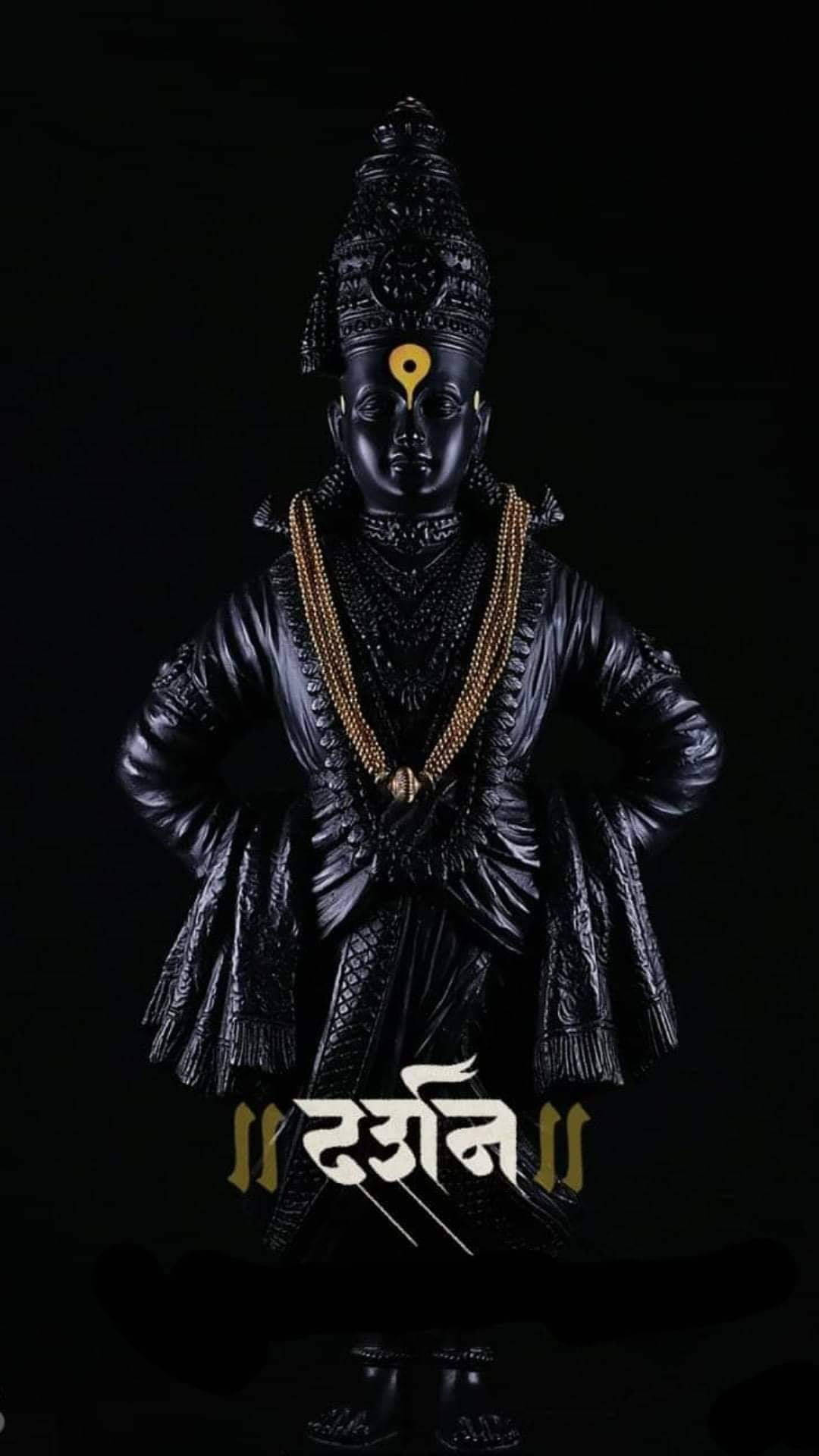 Lord Shiva 桌布 壁紙 — 一尊光滑的黑色印度教女神卡莉雕像，站在裝飾著金色珠寶和神聖蒂拉克標記的黑暗背景前。