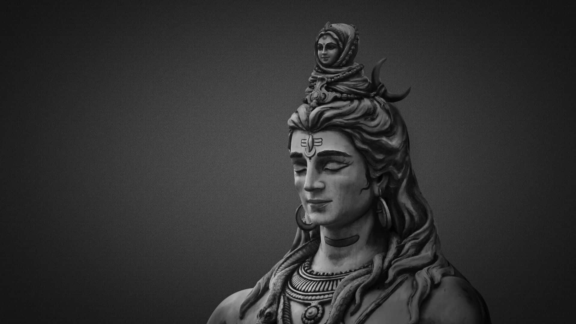 Shiva 桌布 壁紙 — 一尊單色雕像，描繪一位寧靜的神祇，其精緻的頭髮飾有新月和頭頂上的一個小雕像。