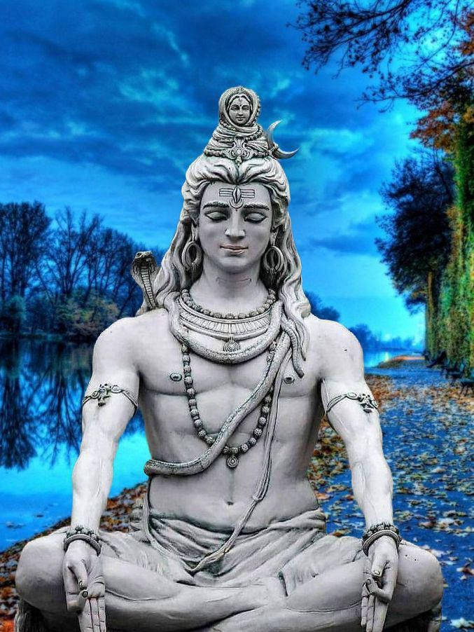 shiv shankar HD 桌布 壁紙 — 一尊寧靜的濕婆神石像，在戲劇性的暮色天空下，於平靜的藍色湖邊冥想。