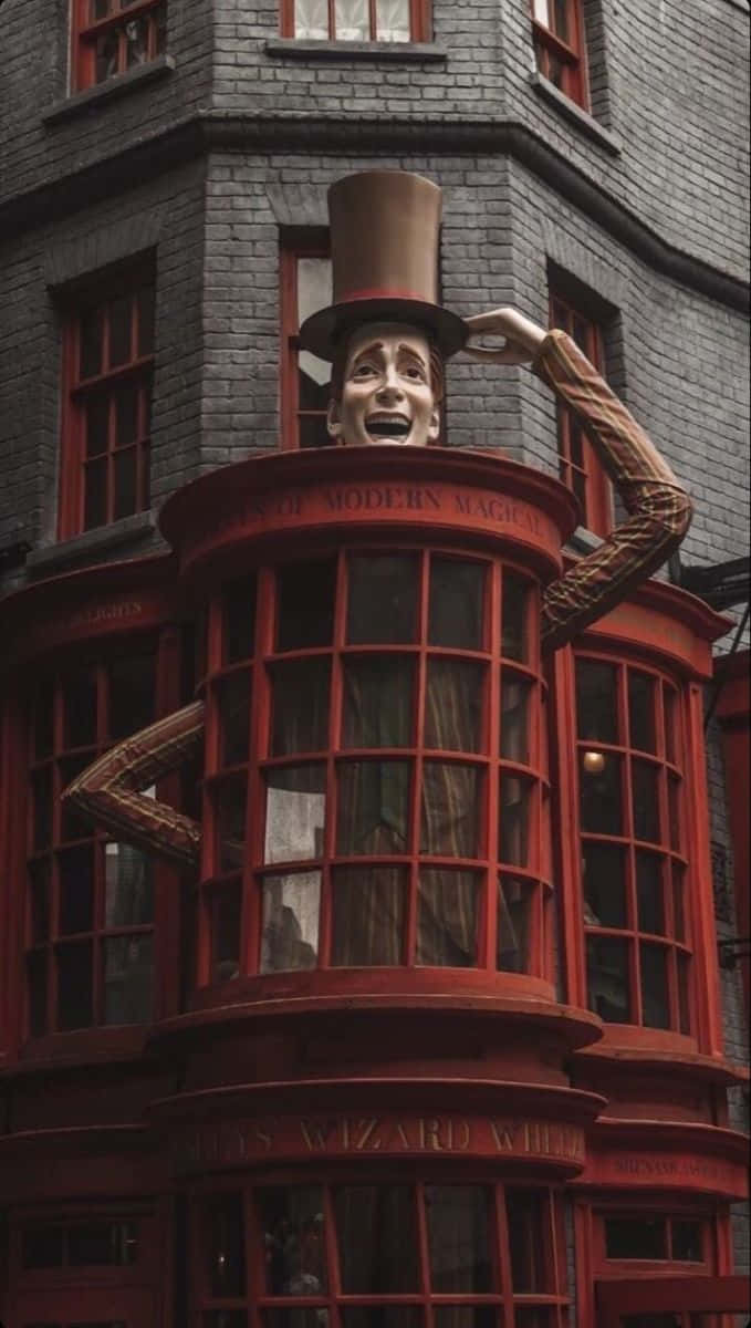 Diagon Alley 桌布 壁紙 — 一尊戴著高帽的奇幻巨型巫師雕像從一棟有華麗窗戶的紅磚建築中冒出。