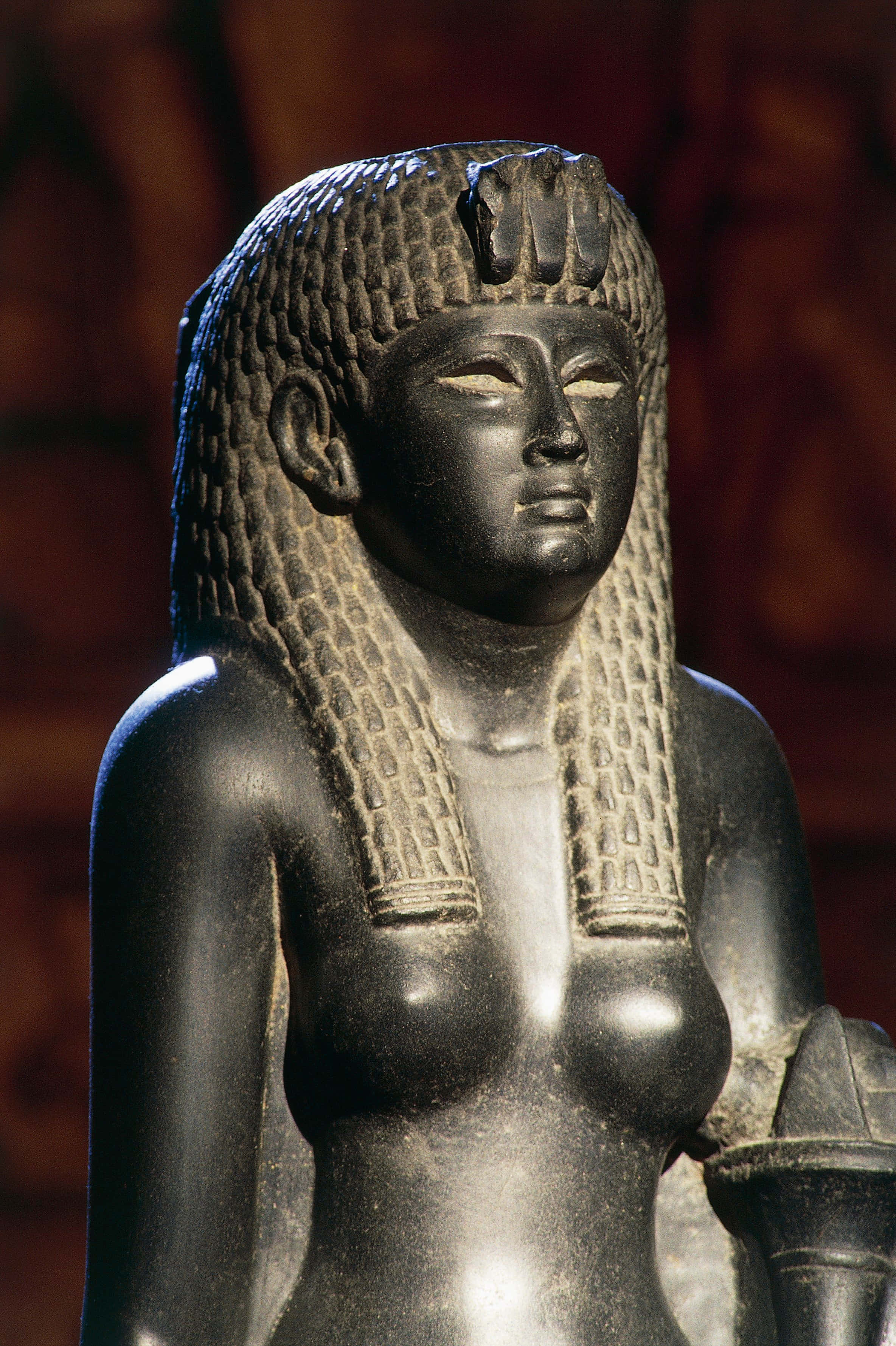 Cleopatra 桌布 壁紙 — 一尊拋光黑色石雕，描繪一位古埃及女王，頭飾精緻，表情寧靜。