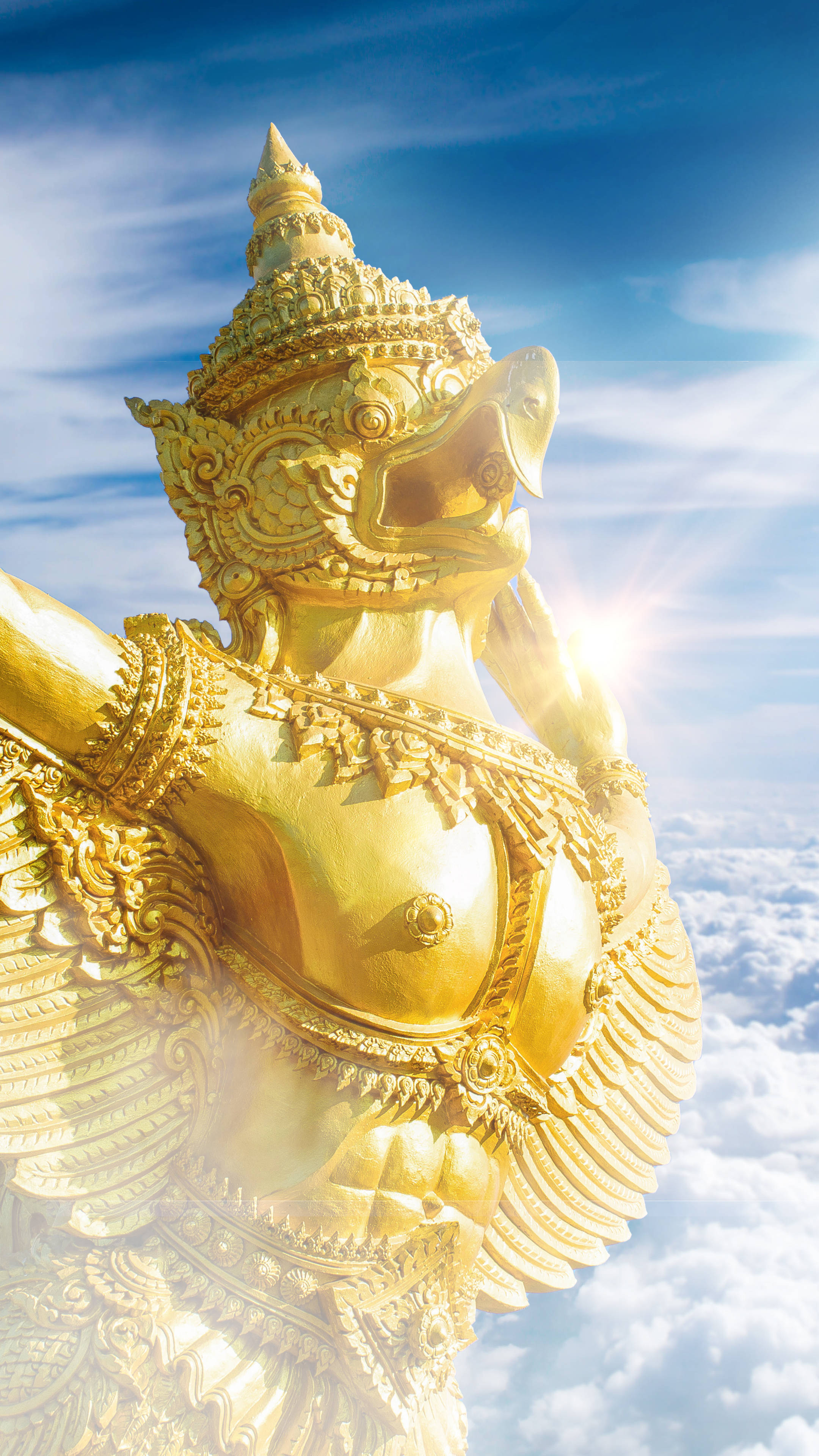 Statue Aesthetic 桌布 壁紙 — 一尊雄偉的金色迦樓羅雕像翱翔於雲端之上，頭後迸發出太陽光芒。