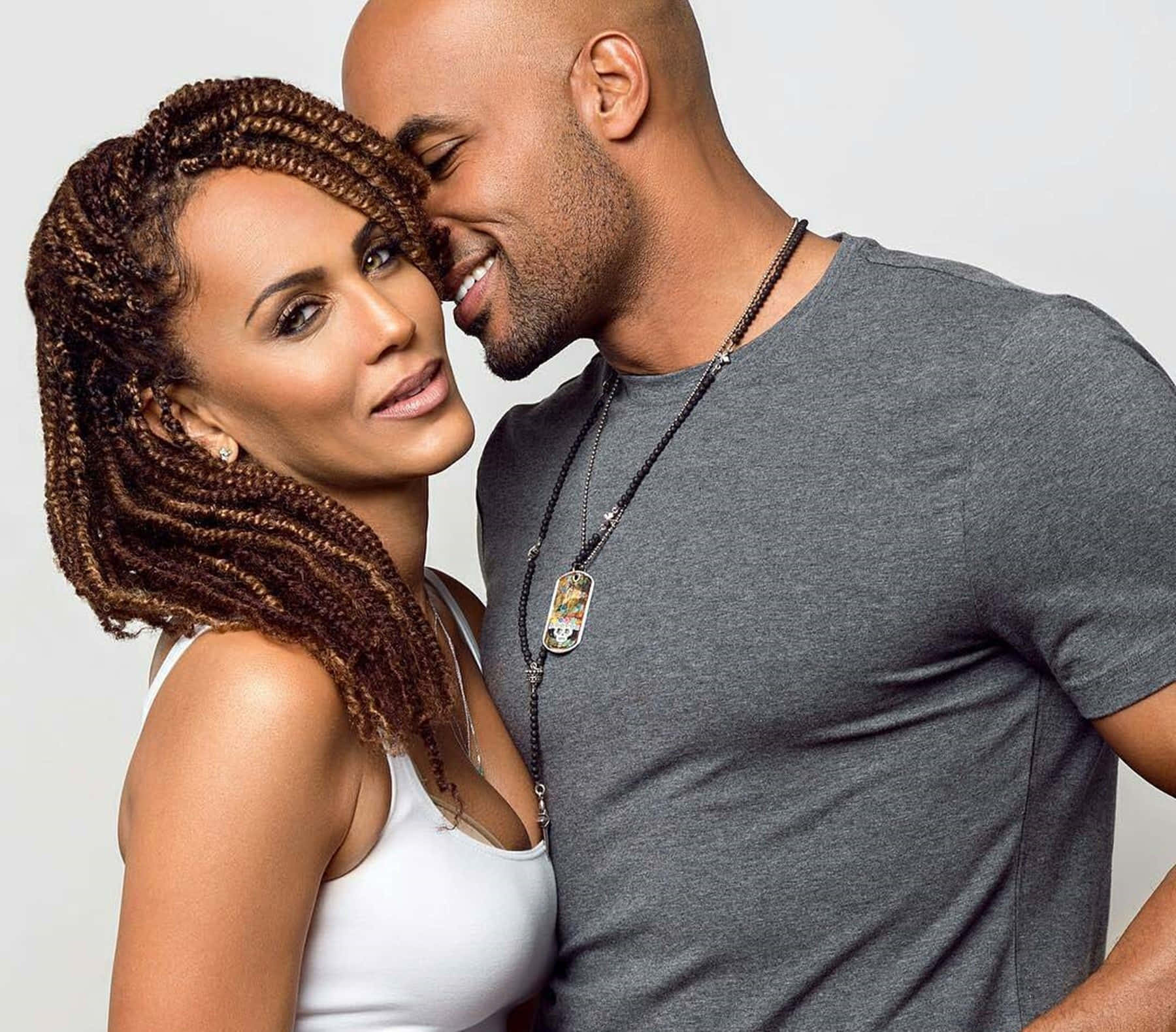 Nicole Ari Parker 桌布 壁紙 — 一對微笑的情侶分享親密時刻，男方在純白背景上輕吻女方的臉頰。