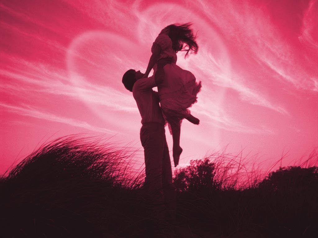 Cute Love 桌布 壁紙 — 一對情侶剪影映襯在充滿活力的粉紅色天空下，有愛心形狀的雲朵，男子開心地抱起女子。
