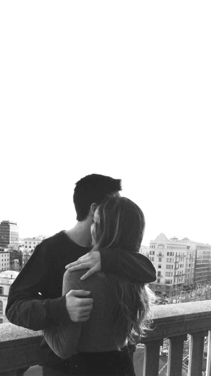 Lovers 桌布 壁紙 — 一對情侶在俯瞰城市景色的陽台上擁抱的黑白照片。