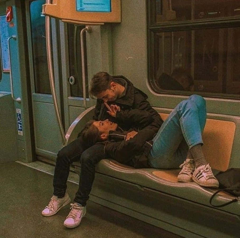 Cute Boyfriend 桌布 壁紙 — 一對情侶在地鐵長椅上親吻，分享親密時刻，燈光溫暖，色調柔和帶綠。
