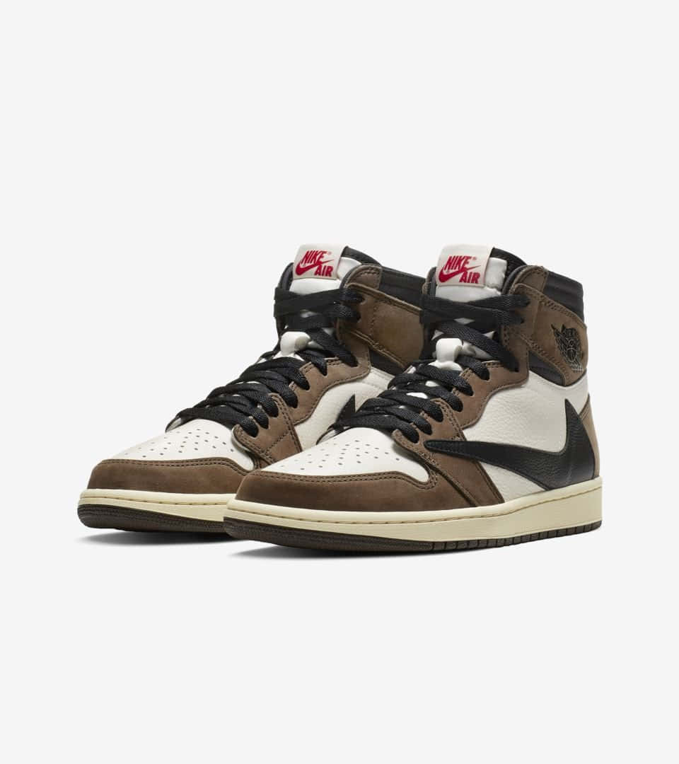 Travis Scott Jordan 1 桌布 壁紙 — 一對棕色、白色和黑色的高筒運動鞋，帶有紅色Nike Air品牌標誌，展示在純白色背景上。
