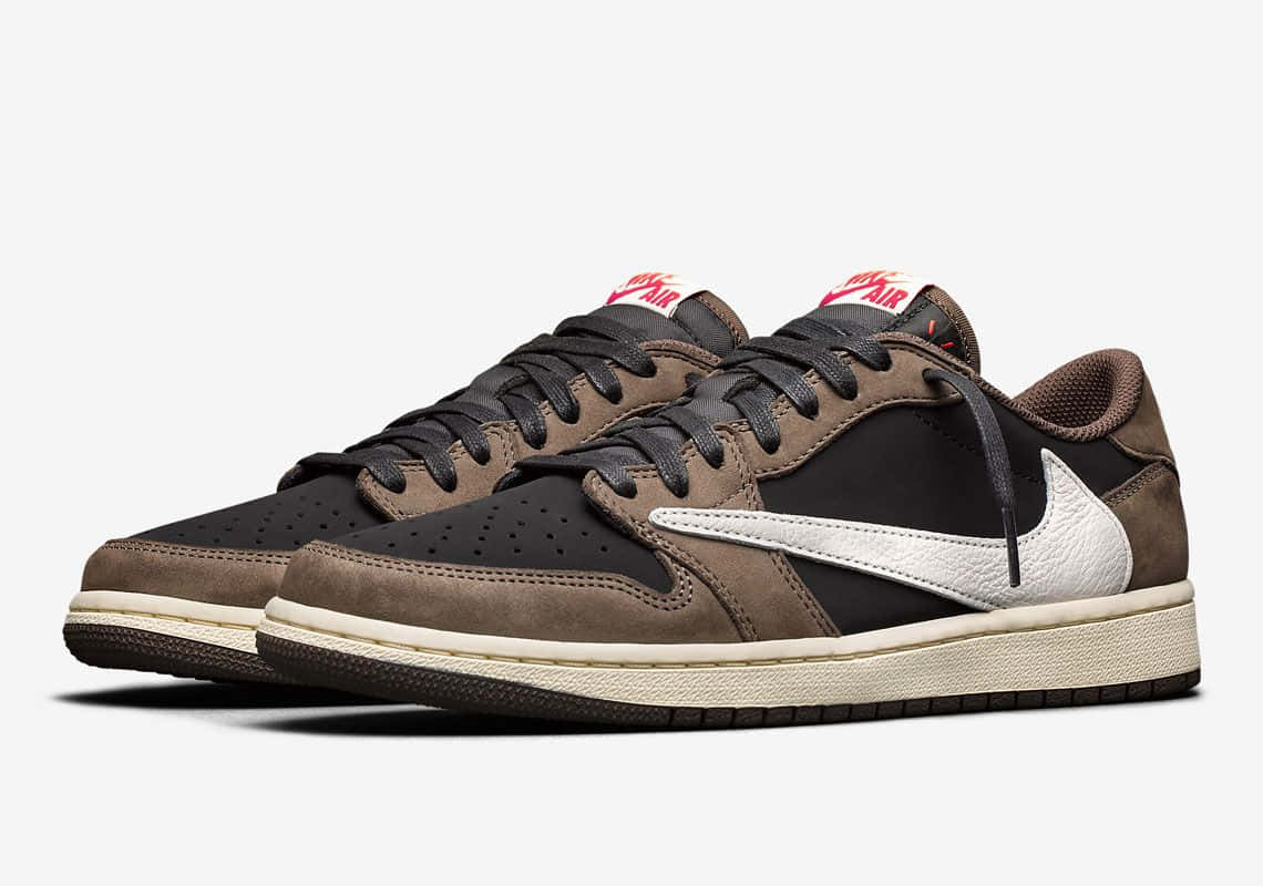 Travis Scott Jordan 1 桌布 壁紙 — 一對棕色和黑色的Nike Air Jordan運動鞋，帶有白色勾勾和紅色鞋舌標籤，展示在純白色背景上。