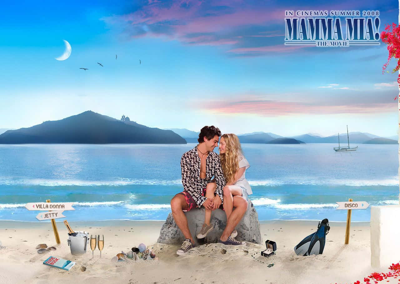 Mamma Mia 桌布 壁紙 — 一對浪漫情侶在日落時分的熱帶海灘上接吻，附近有新月形帆船和路標。