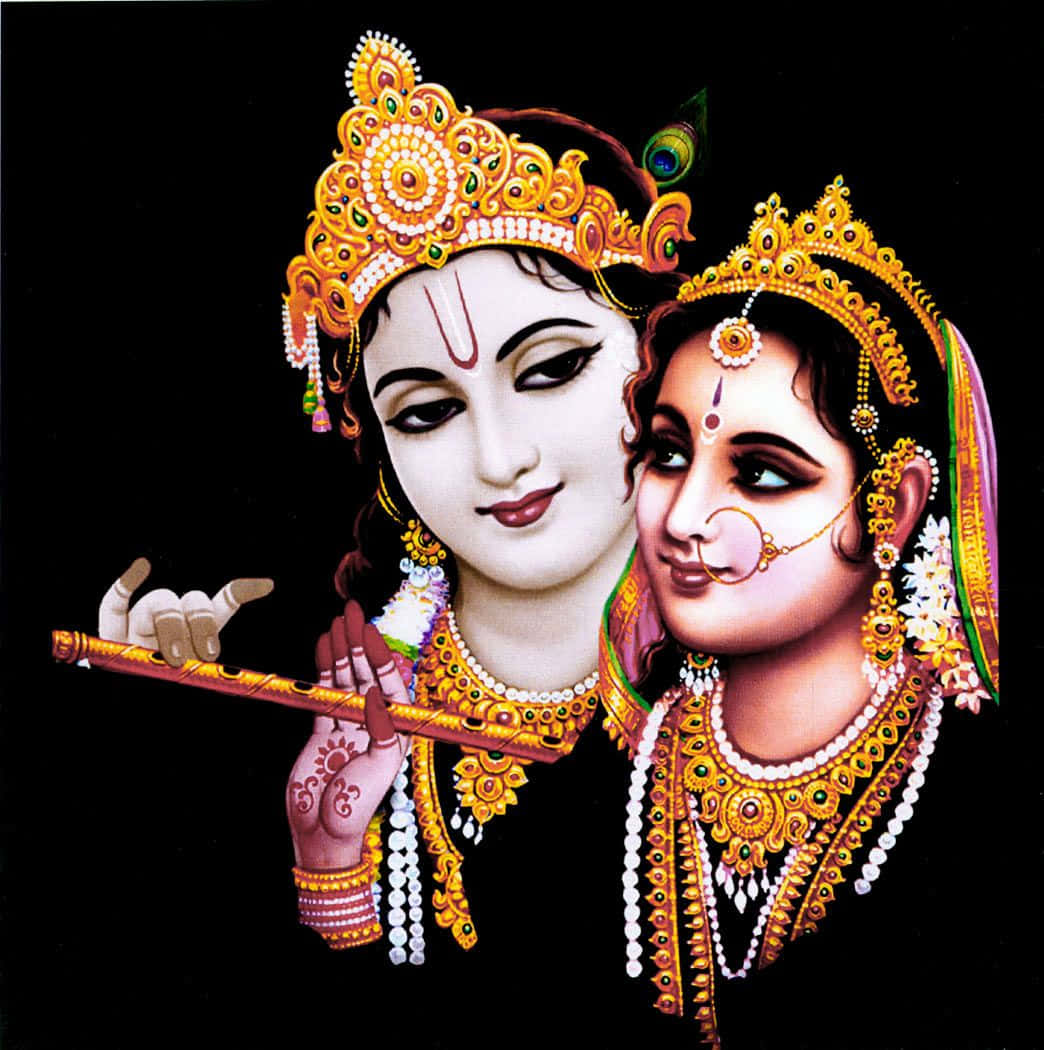 Radha Krishna 桌布 壁紙 — 一對神聖情侶，飾有金色珠寶和孔雀羽毛，背景為黑色，男性吹奏長笛，女性深情凝視。