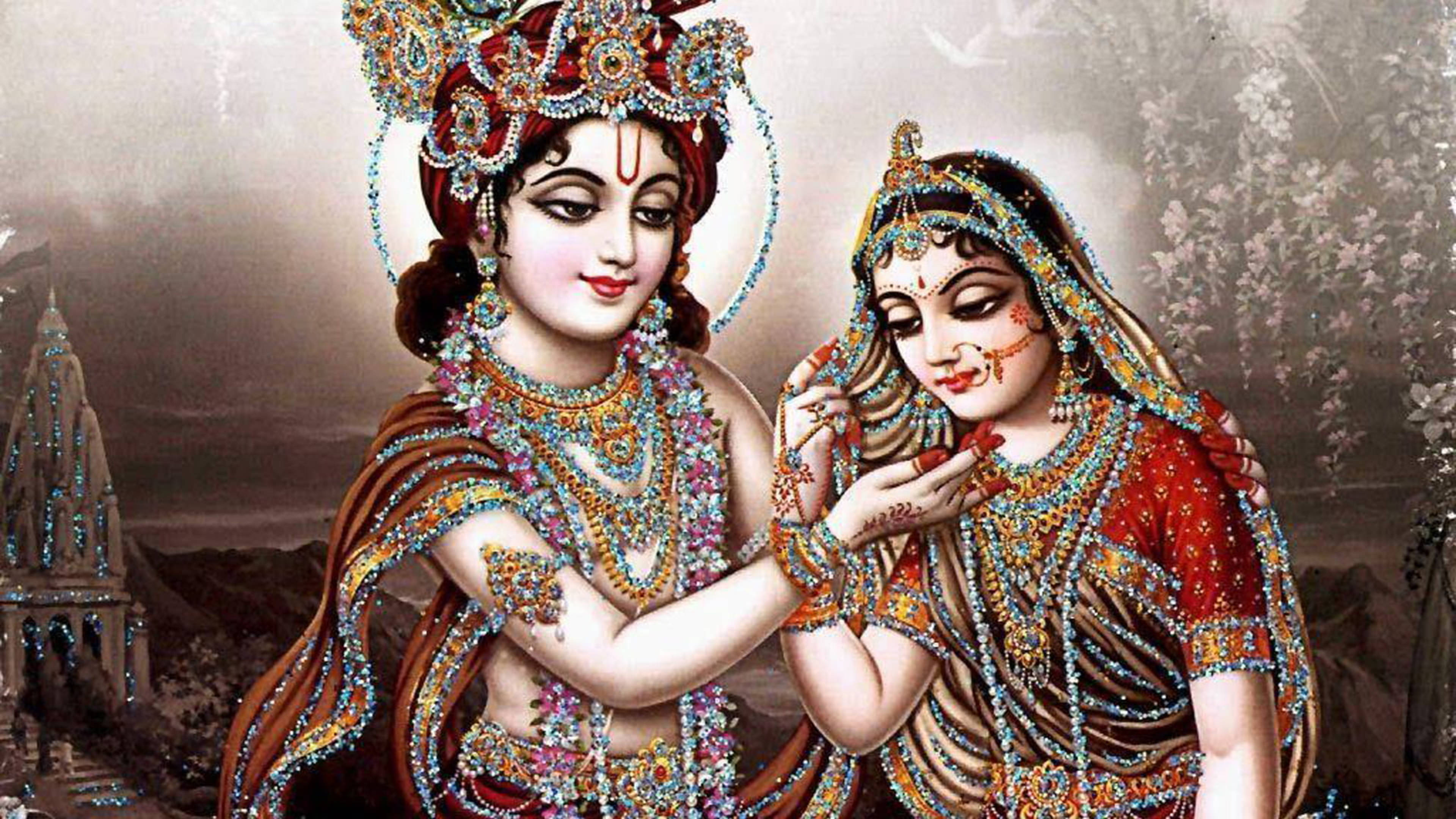krishna ji 桌布 壁紙 — 一對神聖的夫婦身著精緻的珠寶服飾，在寺廟背景下分享溫柔的時刻。