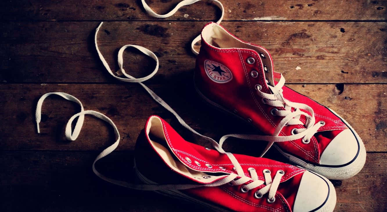 Red Shoes 桌布 壁紙 — 一對紅色高筒Converse運動鞋，鞋帶未繫，擱在磨損的木地板上。