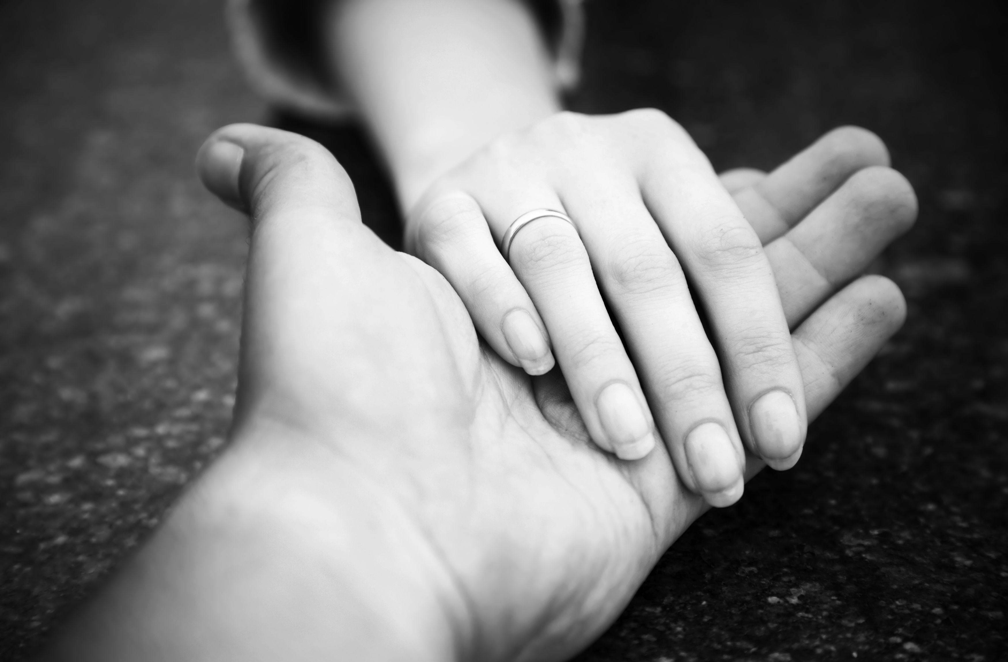 White Full Screen 桌布 壁紙 — 一對緊握的手黑白特寫，無名指上戴著結婚戒指。