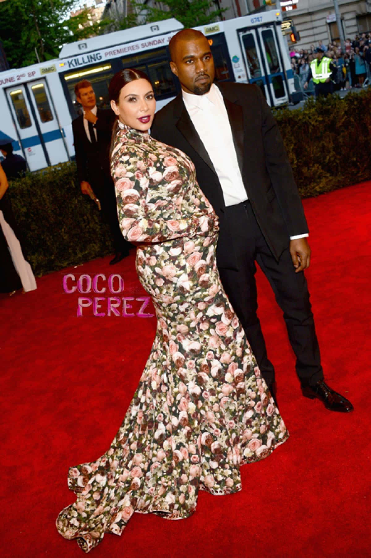 Met Gala 桌布 壁紙 — 一對魅力情侶穿著花卉禮服和正式西裝，在高規格活動的紅地毯上擺姿勢。