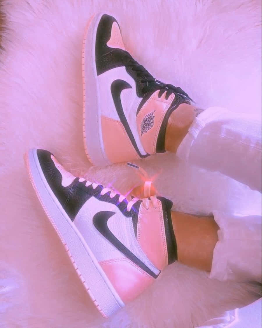 Pink Shoes 桌布 壁紙 — 一對黑、白、粉紅色的Jordan 1波鞋放在毛絨粉紅色地毯上，鞋帶發光。