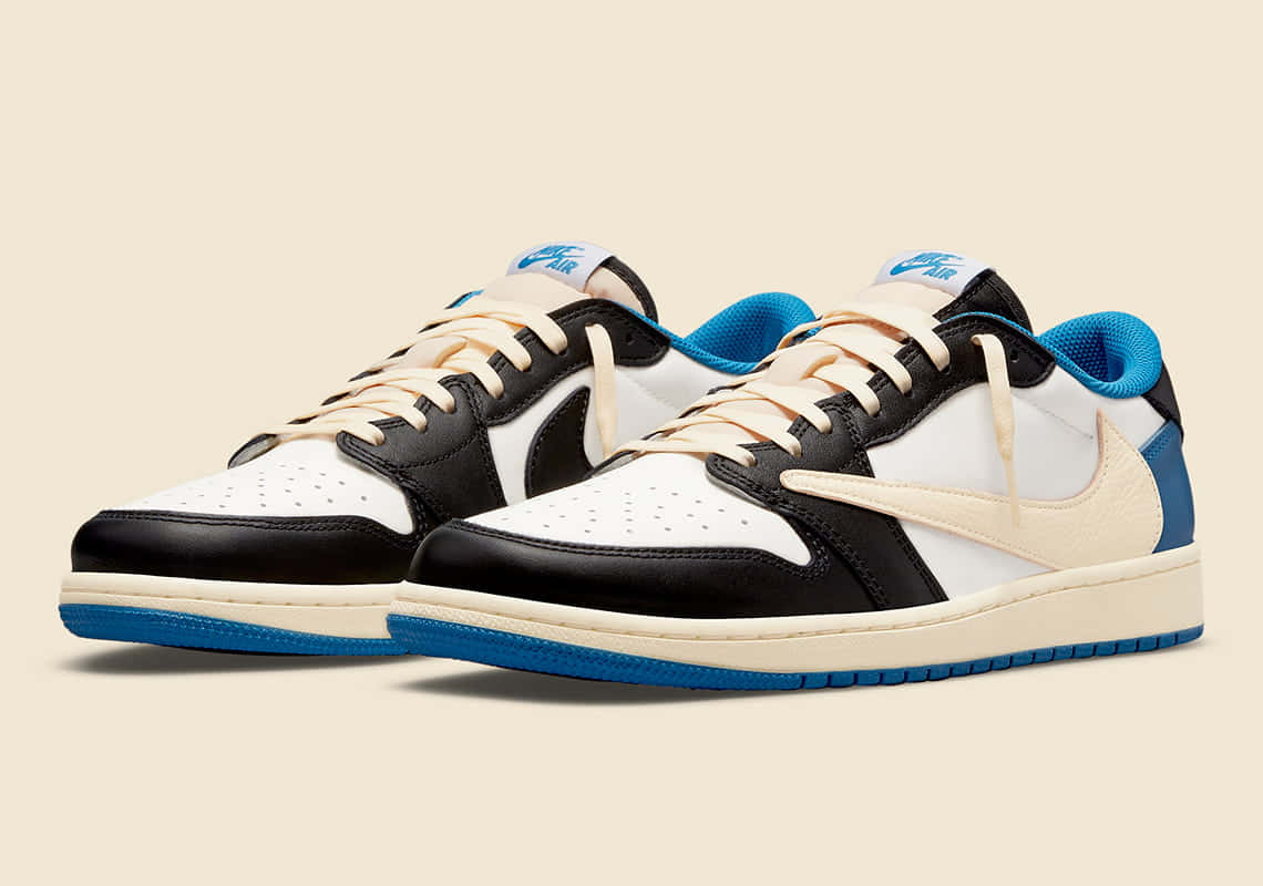 Travis Scott Jordan 1 桌布 壁紙 — 一對黑色、白色和藍色的Nike Air Jordan運動鞋，配以奶油色鞋帶和米色背景。