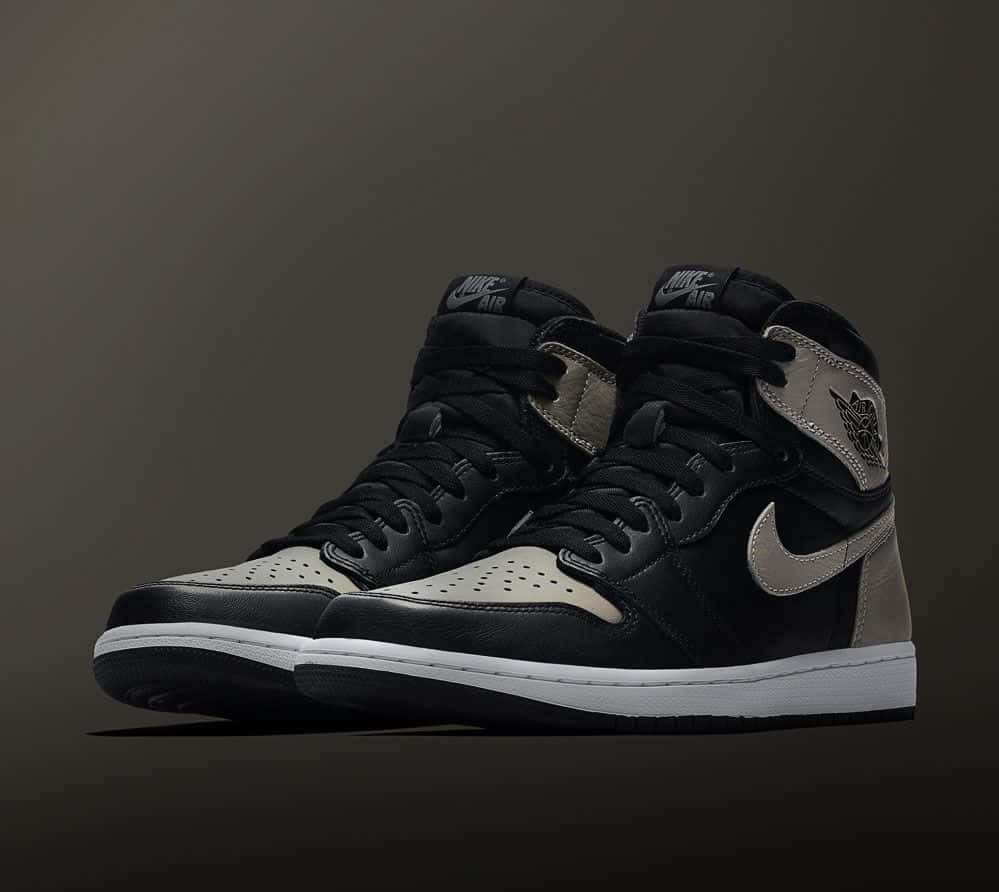Travis Scott Jordan 1 桌布 壁紙 — 一對黑色和米色高筒運動鞋，白色鞋底，展示在深色漸變背景上。