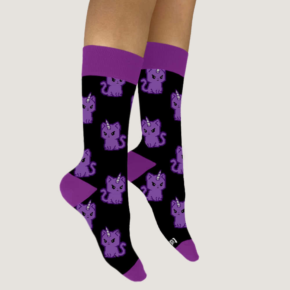 Purple Socks 桌布 壁紙 — 一對黑色襪子，帶有紫色獨角貓圖案和紫色飾邊，穿在腿上，背景為純色。