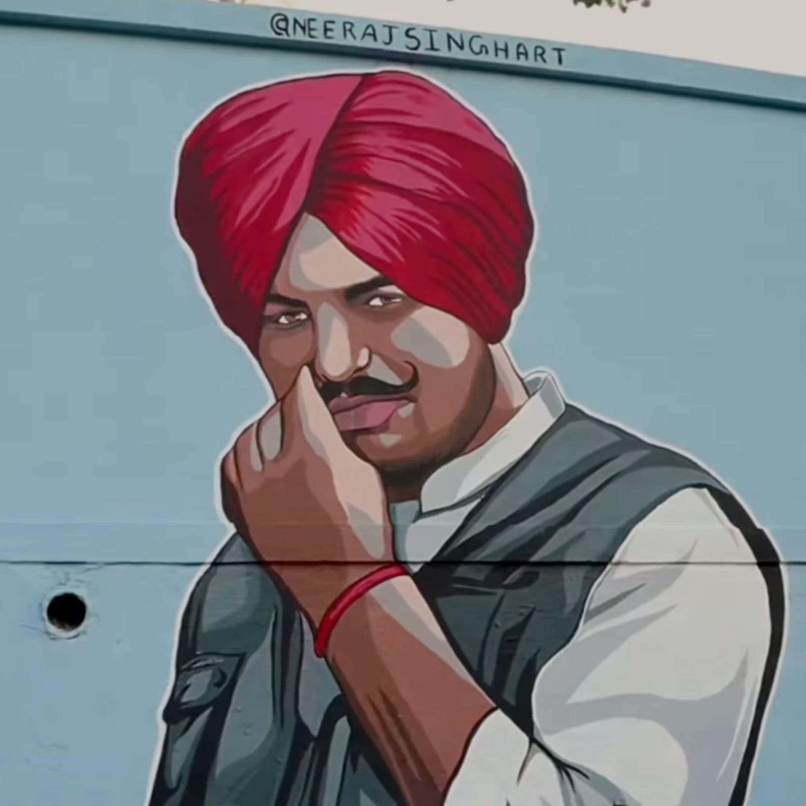 Sidhu Moose Wala 桌布 壁紙 — 一幅充滿活力的壁畫描繪了一名戴紅色頭巾和背心的男子，表情若有所思，手靠近臉部。