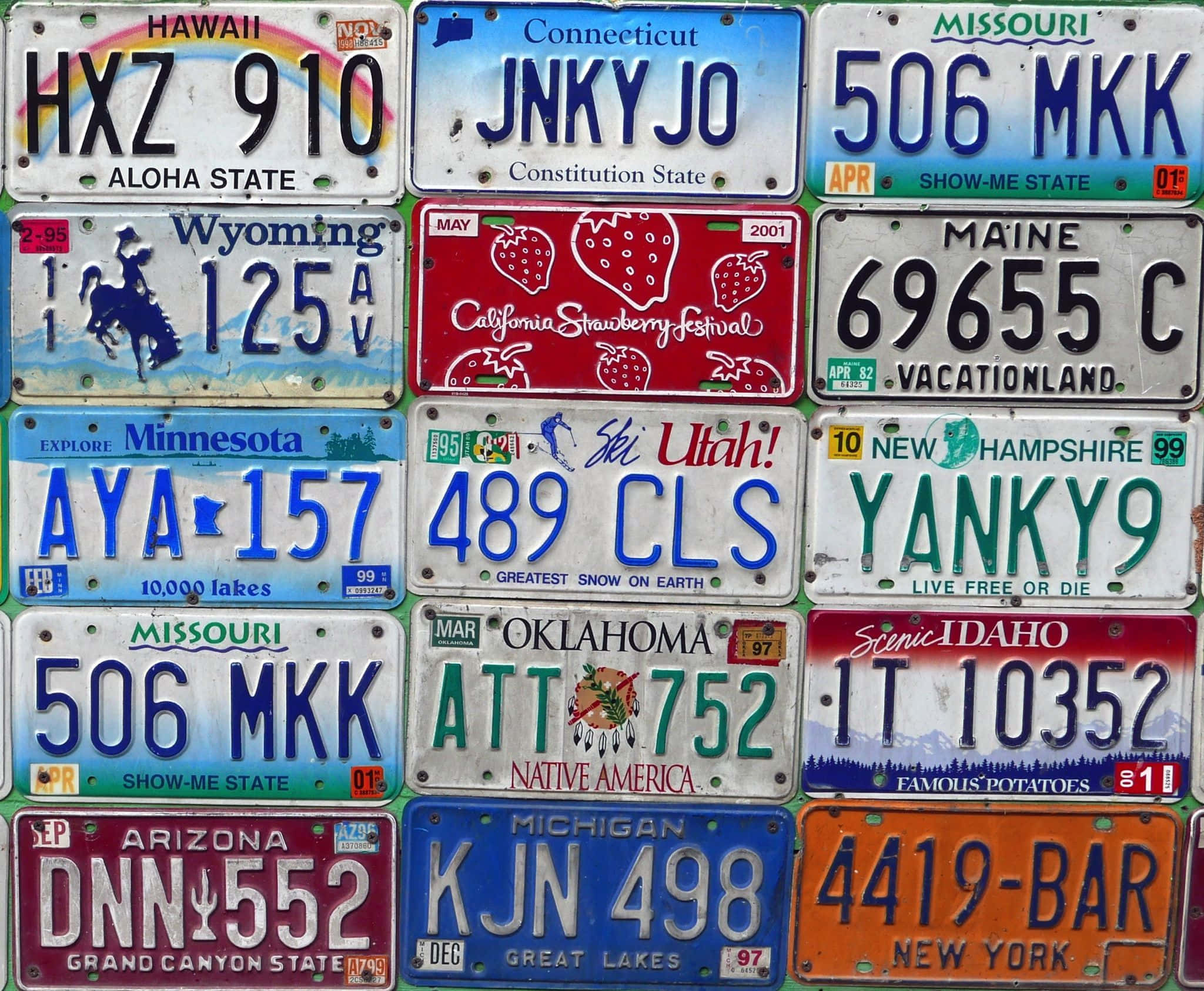 Car License Plate 桌布 壁紙 — 一幅充滿活力的拼貼畫，由色彩繽紛的美國各州車牌組成，以密集網格排列，展現地區自豪感和古怪標語。
