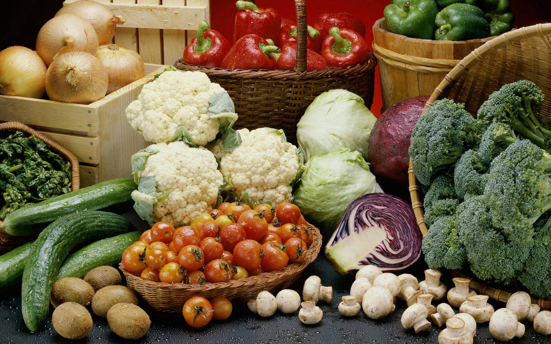 Vegetable 桌布 壁紙 — 一幅充滿活力的靜物畫，描繪了西蘭花、椰菜花、車厘茄和蘑菇等新鮮蔬菜，整齊地擺放在深色表面上的籃子裡。