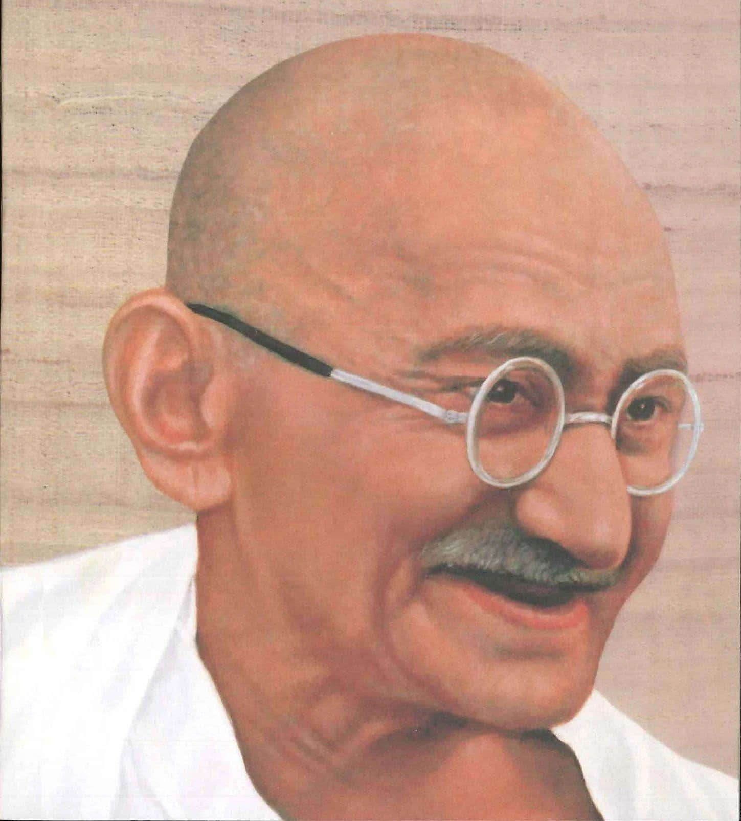 Mahatma Gandhi 桌布 壁紙 — 一幅寧靜的聖雄甘地肖像，戴著圓形眼鏡，露出溫柔的微笑，背景是帶有紋理的米色。