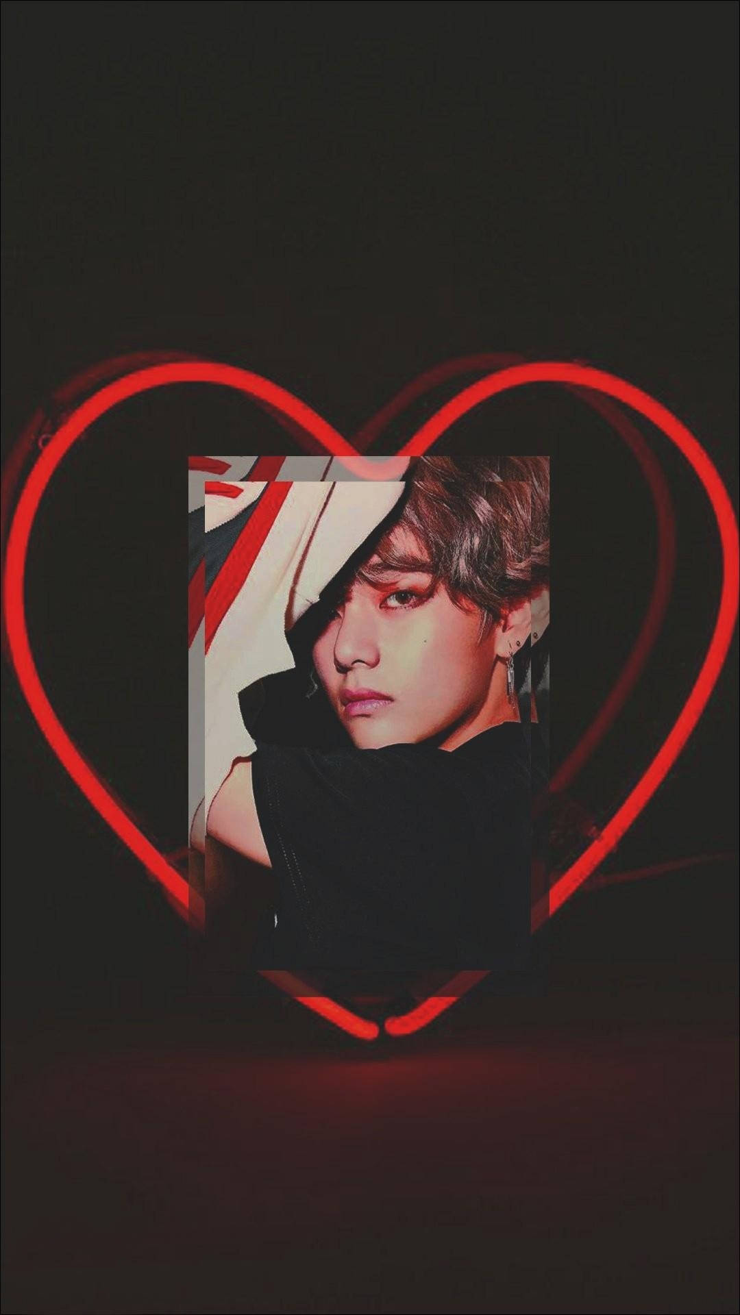 Kpop Aesthetic 桌布 壁紙 — 一幅年輕男子的肖像，被發光的紅色霓虹心形線條框住，背景為深色。