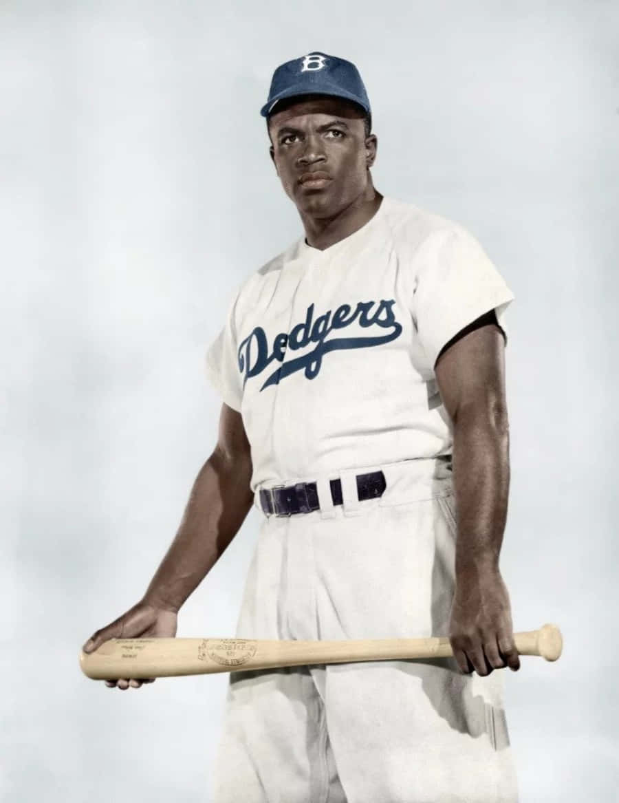 Jackie Robinson 桌布 壁紙 — 一幅復古肖像，展示一位身穿道奇隊制服的非裔棒球選手，在簡約的攝影棚背景前手持木製球棒。