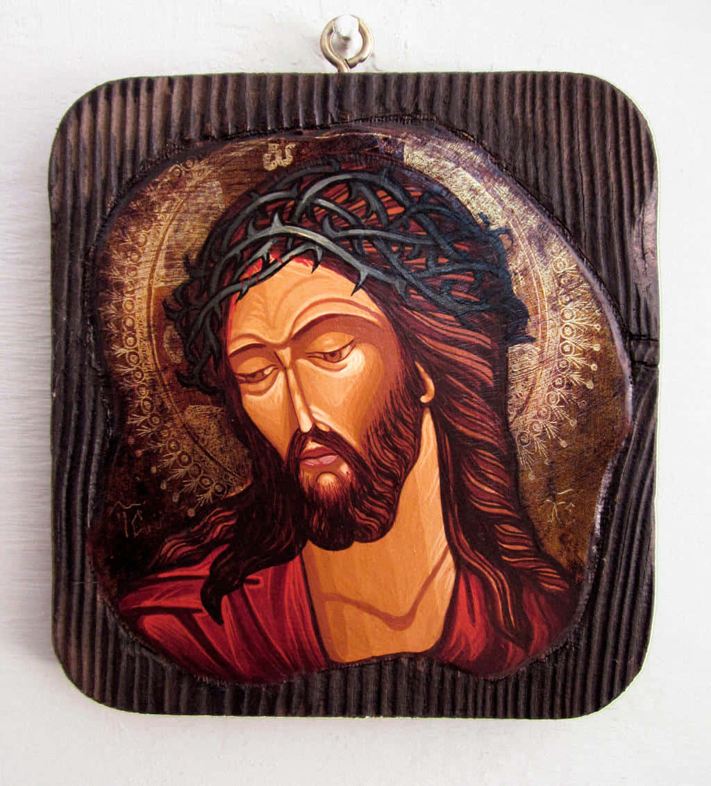 Jesus Crown Of Thorns 桌布 壁紙 — 一幅莊嚴的耶穌畫像，頭戴荊棘冠冕，置於帶有金色光環的深色木板上。