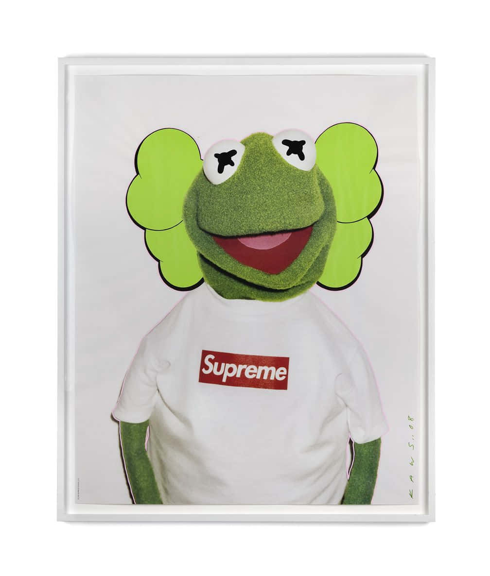 Kaws X Supreme 桌布 壁紙 — 一幅裱框的青蛙柯密特肖像，身穿帶有紅色標誌的白色Supreme T恤，背景為純白色。