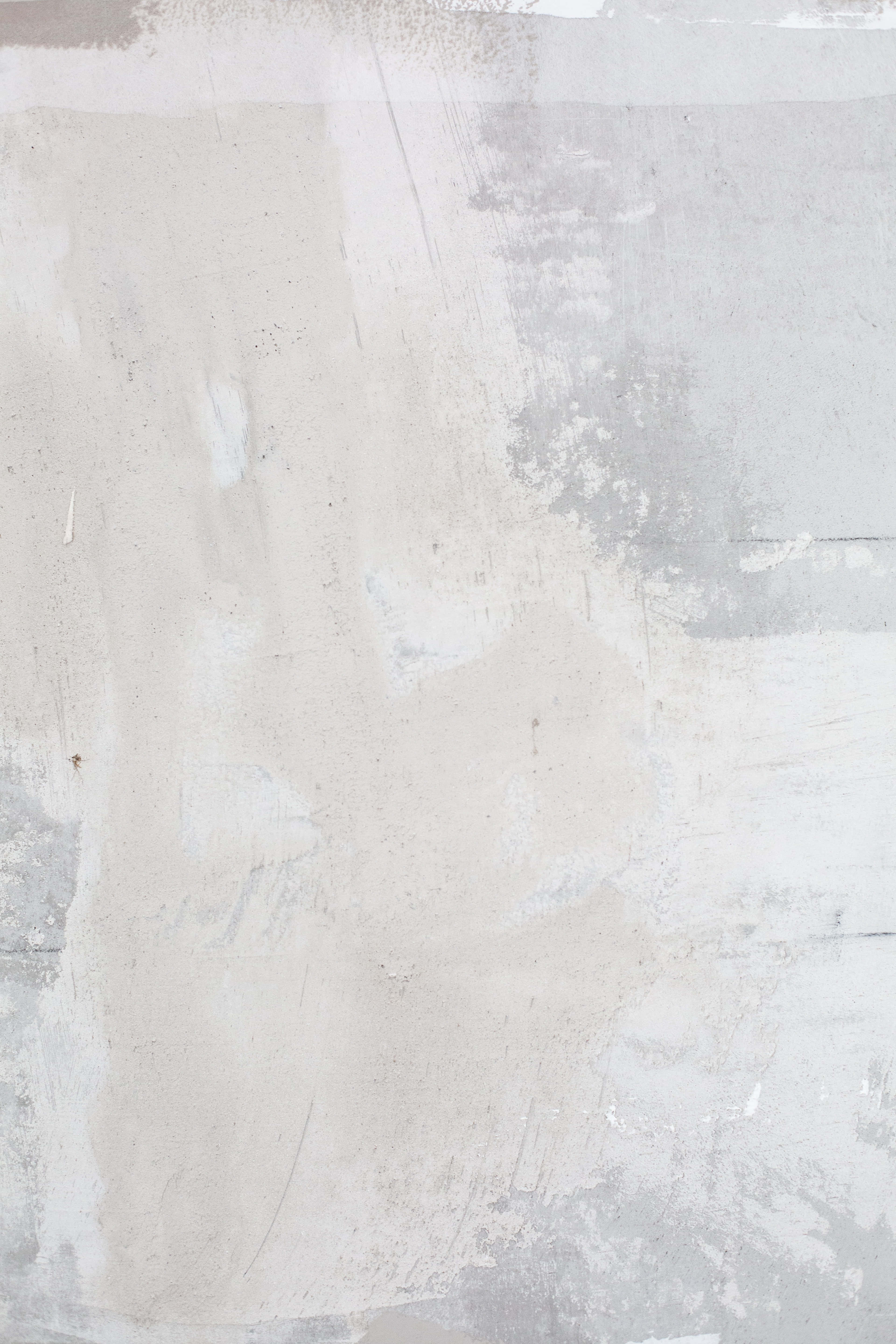 Paint Texture 桌布 壁紙 — 一幅風化混凝土牆的特寫，帶有褪色白漆斑點和可見的筆觸。