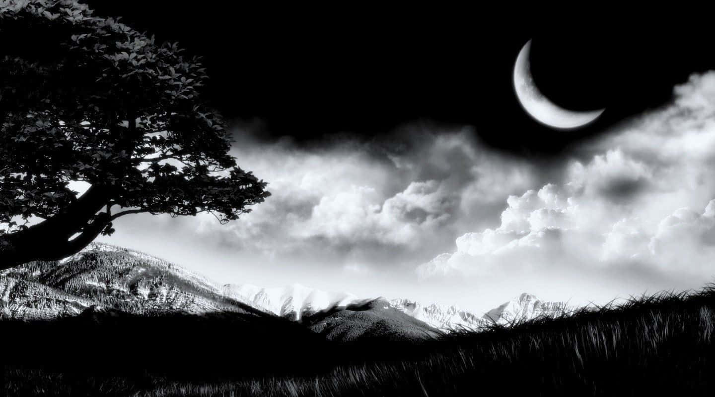 Dark Nature 桌布 壁紙 — 一幅鮮明的黑白風景，新月和戲劇性的雲層下，一棵孤樹在積雪覆蓋的山脈前形成剪影。