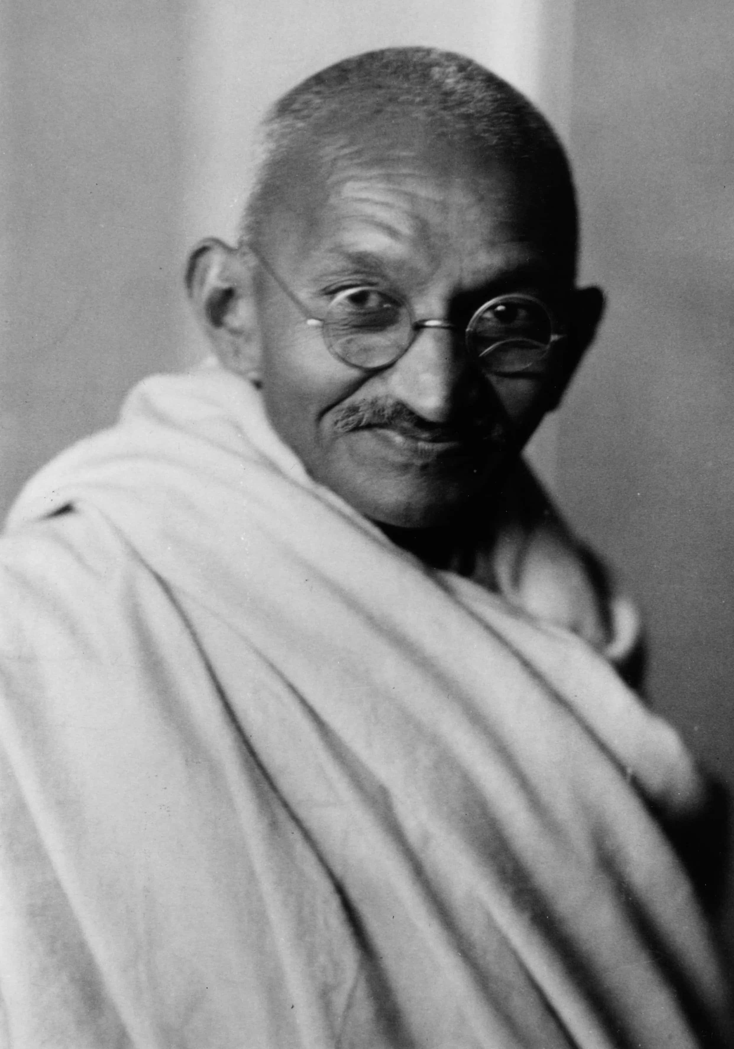 Mahatma Gandhi 桌布 壁紙 — 一幅黑白肖像，聖雄甘地戴著圓形眼鏡和披著白色布料，溫柔微笑。