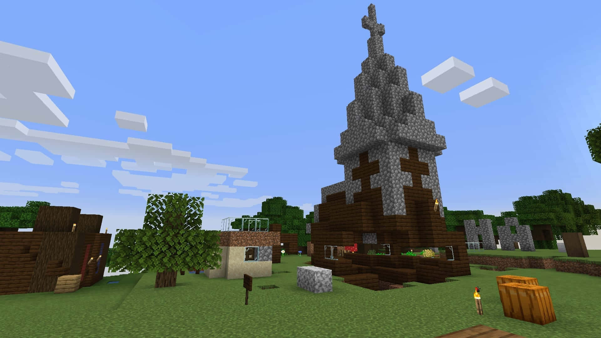 Minecraft Server 桌布 壁紙 — 一座像素化的Minecraft教堂，擁有石製尖頂和木製底座，矗立在一個長滿草的村莊中，上方是明亮的藍天和方塊狀雲朵。