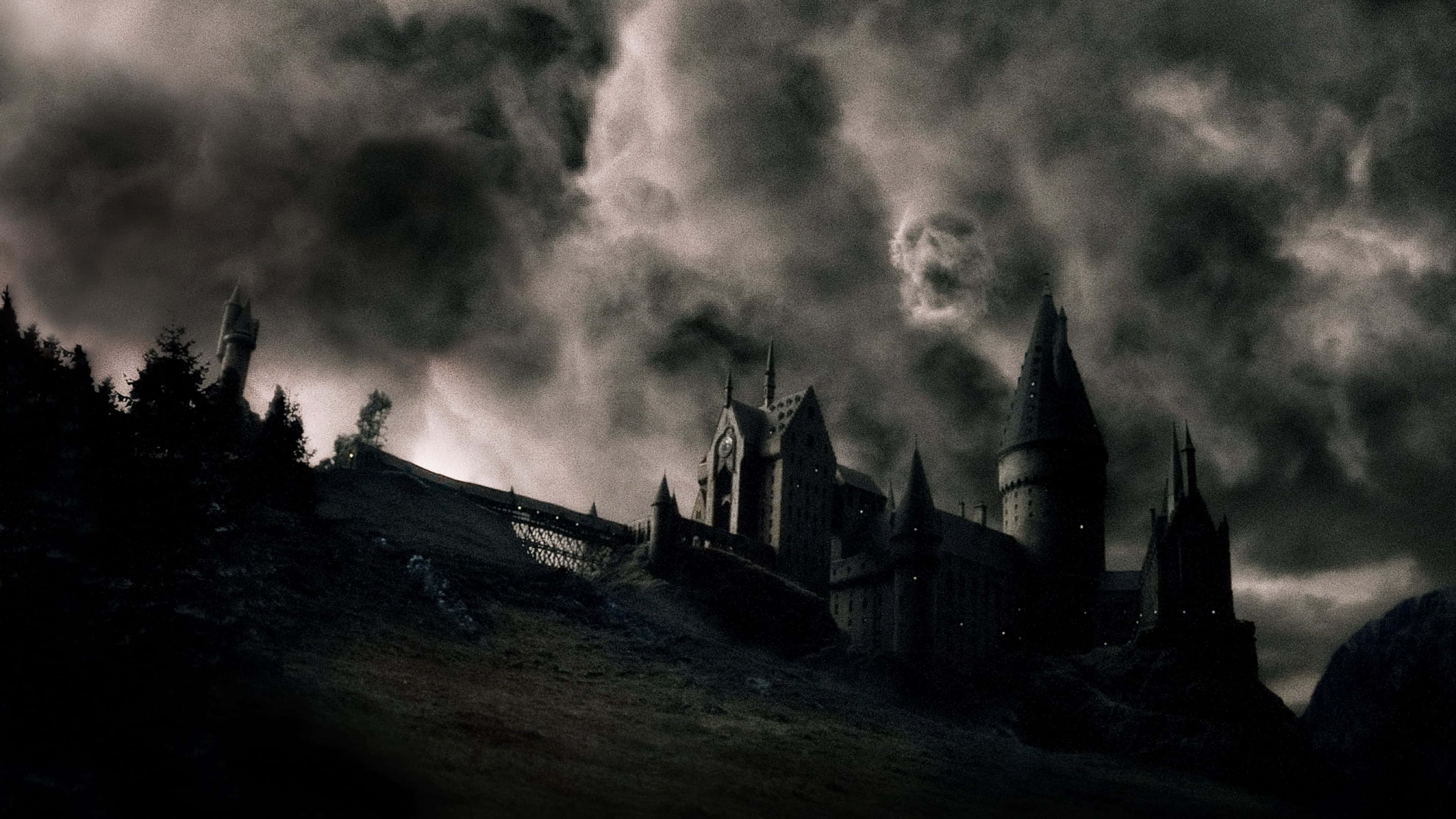 The Half-blood Prince 桌布 壁紙 — 一座哥德式城堡坐落在山丘上，上方是風暴天空，烏雲翻滾。