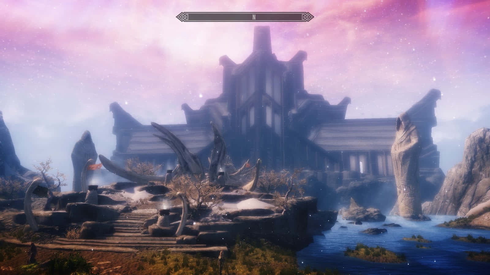 Sovngarde 桌布 壁紙 — 一座宏偉的古代遺跡，有龍骨和石像，矗立在河邊，天空呈現粉紅和紫色的暮色。