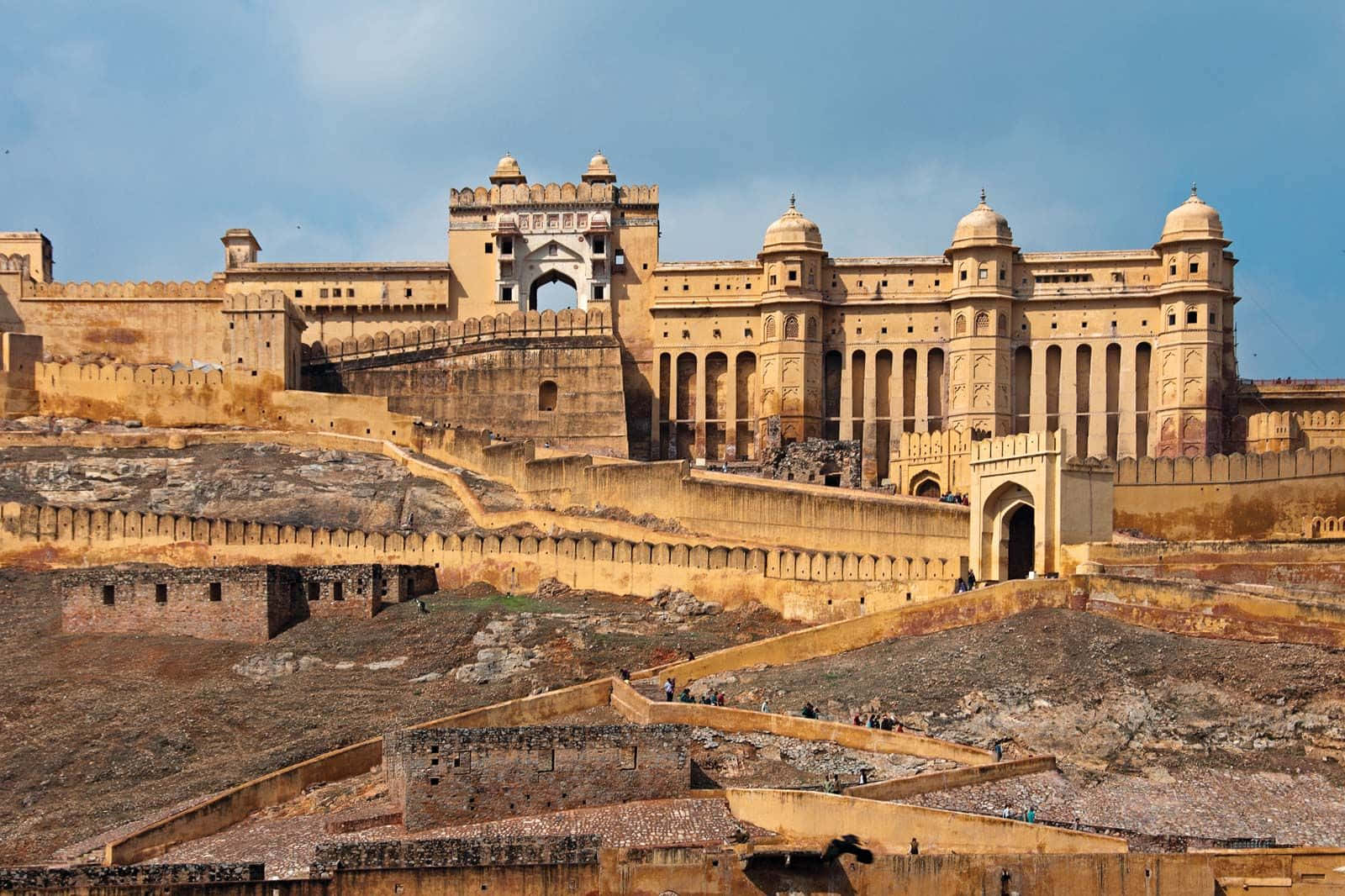 Rajasthan 桌布 壁紙 — 一座宏偉的歷史堡壘，擁有砂岩牆壁和圓頂塔樓，在清澈的藍天下巍然聳立。