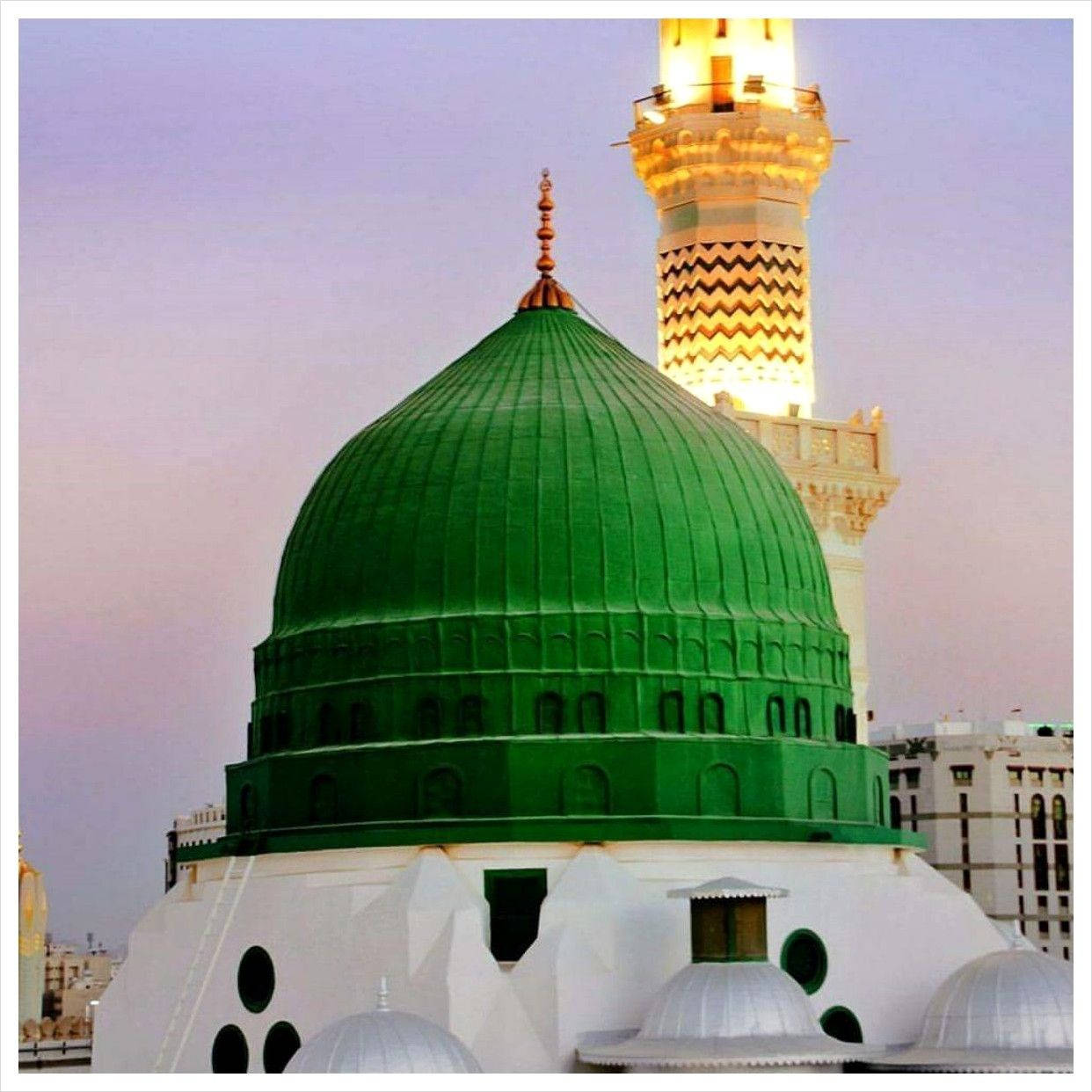 Madina Sharif 桌布 壁紙 — 一座宏偉的清真寺，擁有充滿活力的綠色圓頂和燈火通明的宣禮塔，在柔和的暮色天空下巍然聳立。