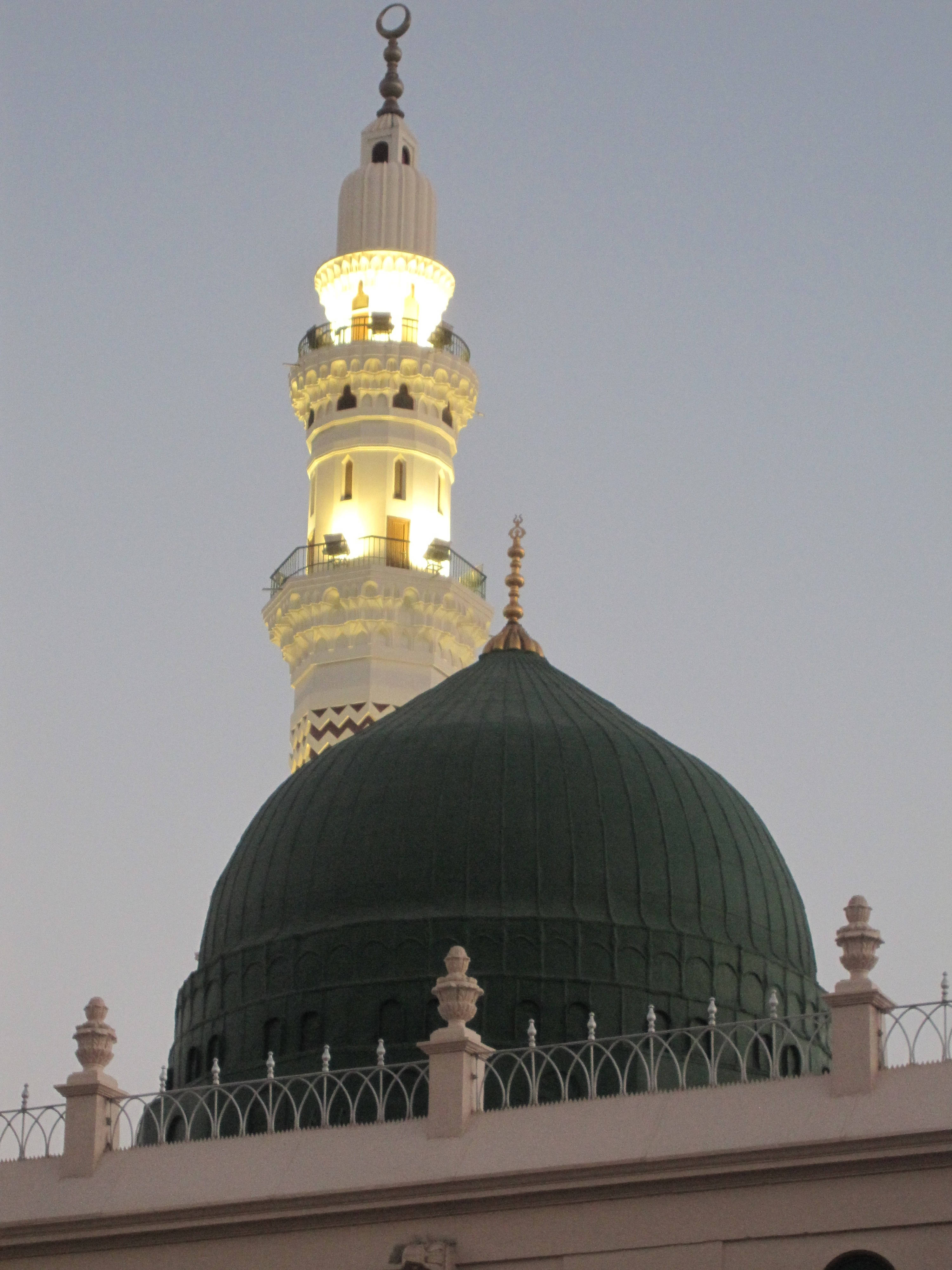Madina Sharif 桌布 壁紙 — 一座宏偉的清真寺圓頂和發光的宣禮塔在柔和的暮色天空中閃耀。