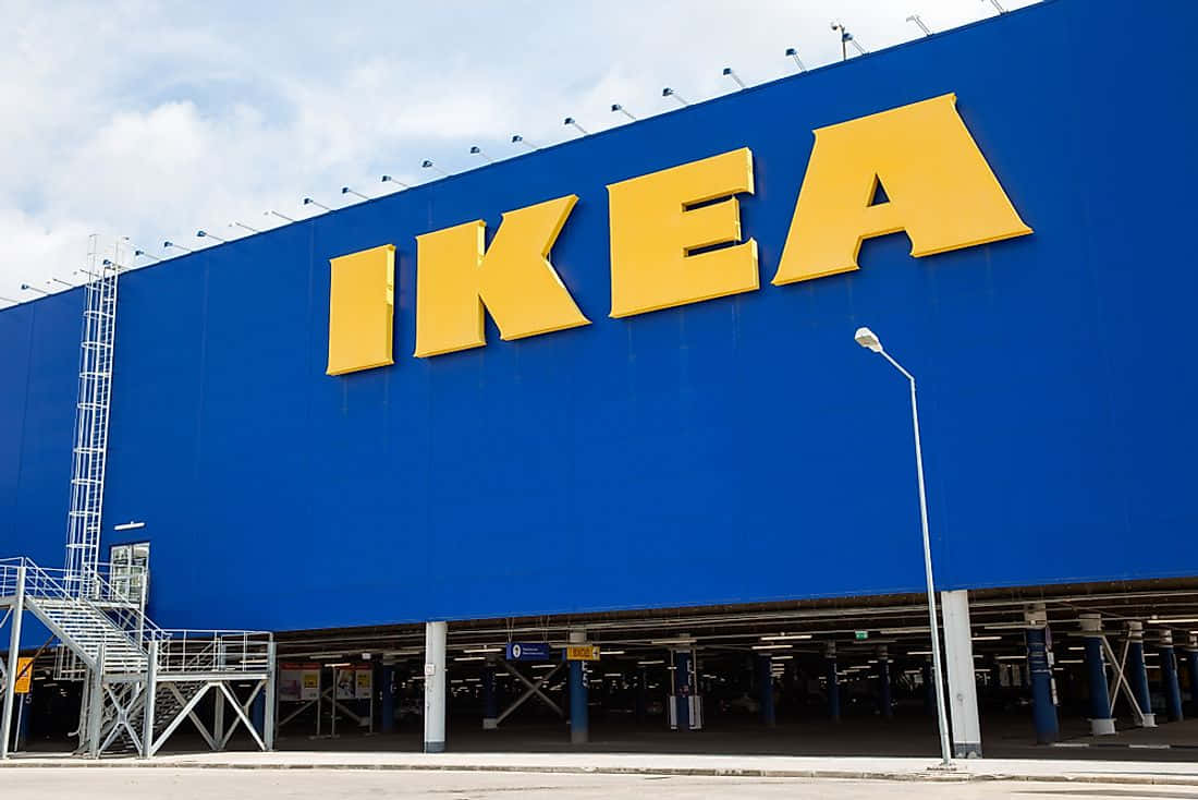 Ikea 桌布 壁紙 — 一座巨大的藍色IKEA商店建築，在部分多雲的天空下帶有醒目的黃色標牌。