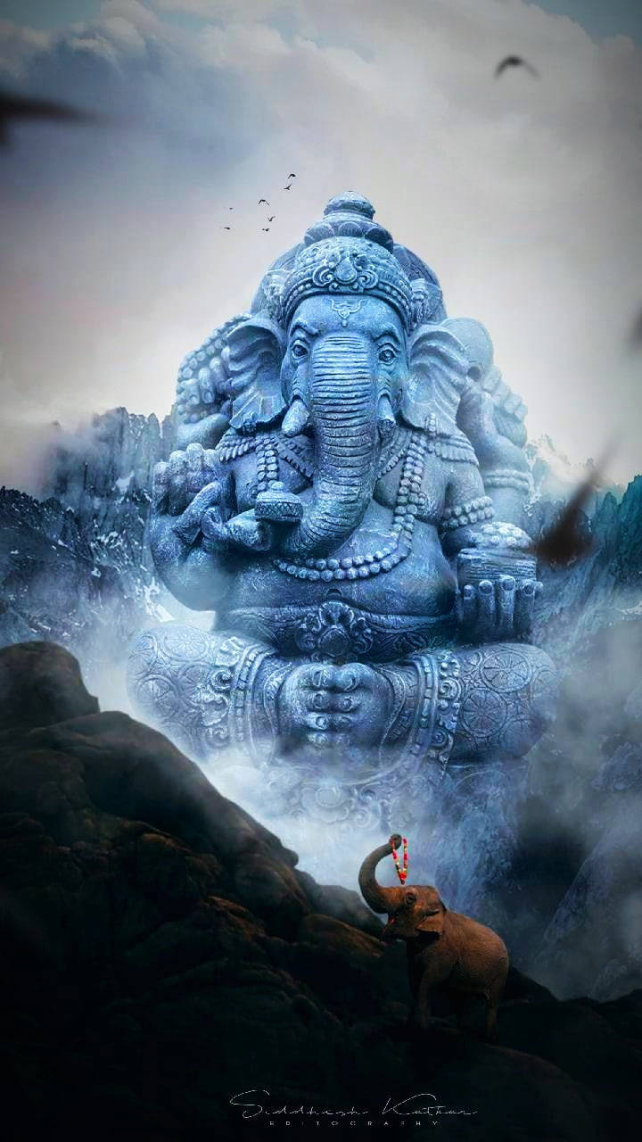 hindu iPhone 桌布 壁紙 — 一座巨大的藍色石頭象神雕像從霧氣繚繞的山中浮現，一隻小象在其底部獻花。