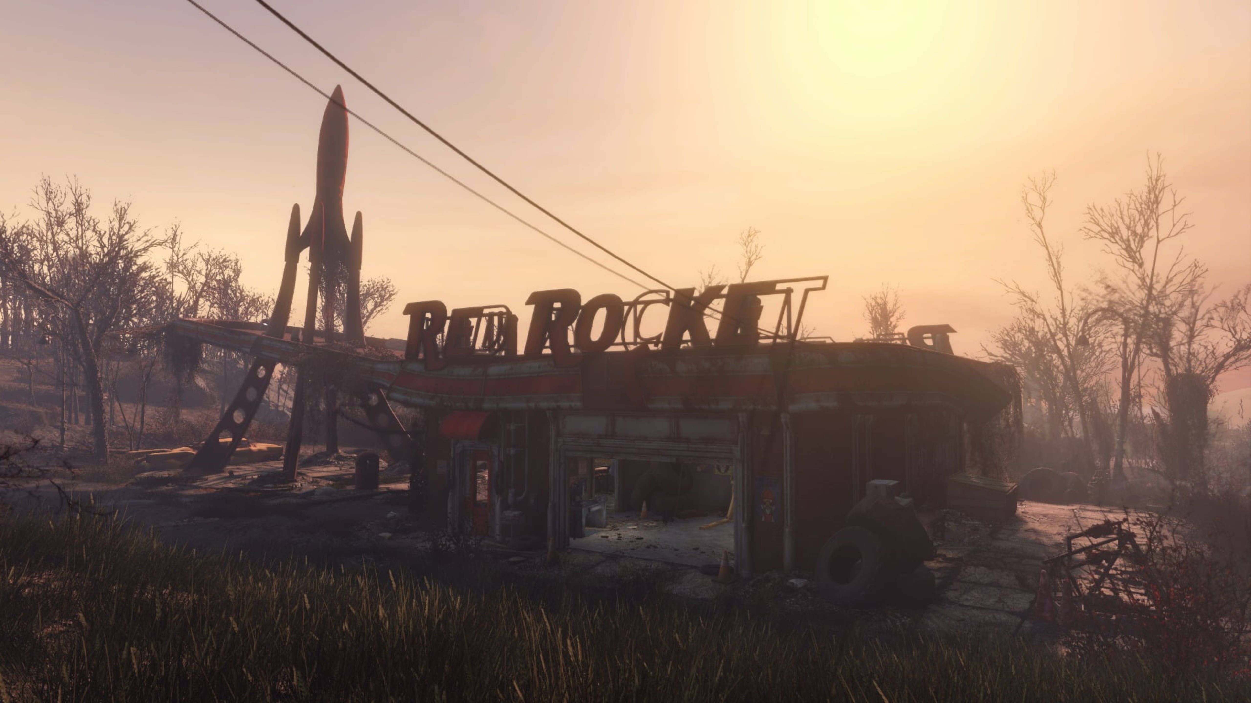 Fallout 4 桌布 壁紙 — 一座破敗的Red Rocket加油站矗立在荒涼的廢土上，夕陽下有一座火箭雕塑和光禿禿的樹木。