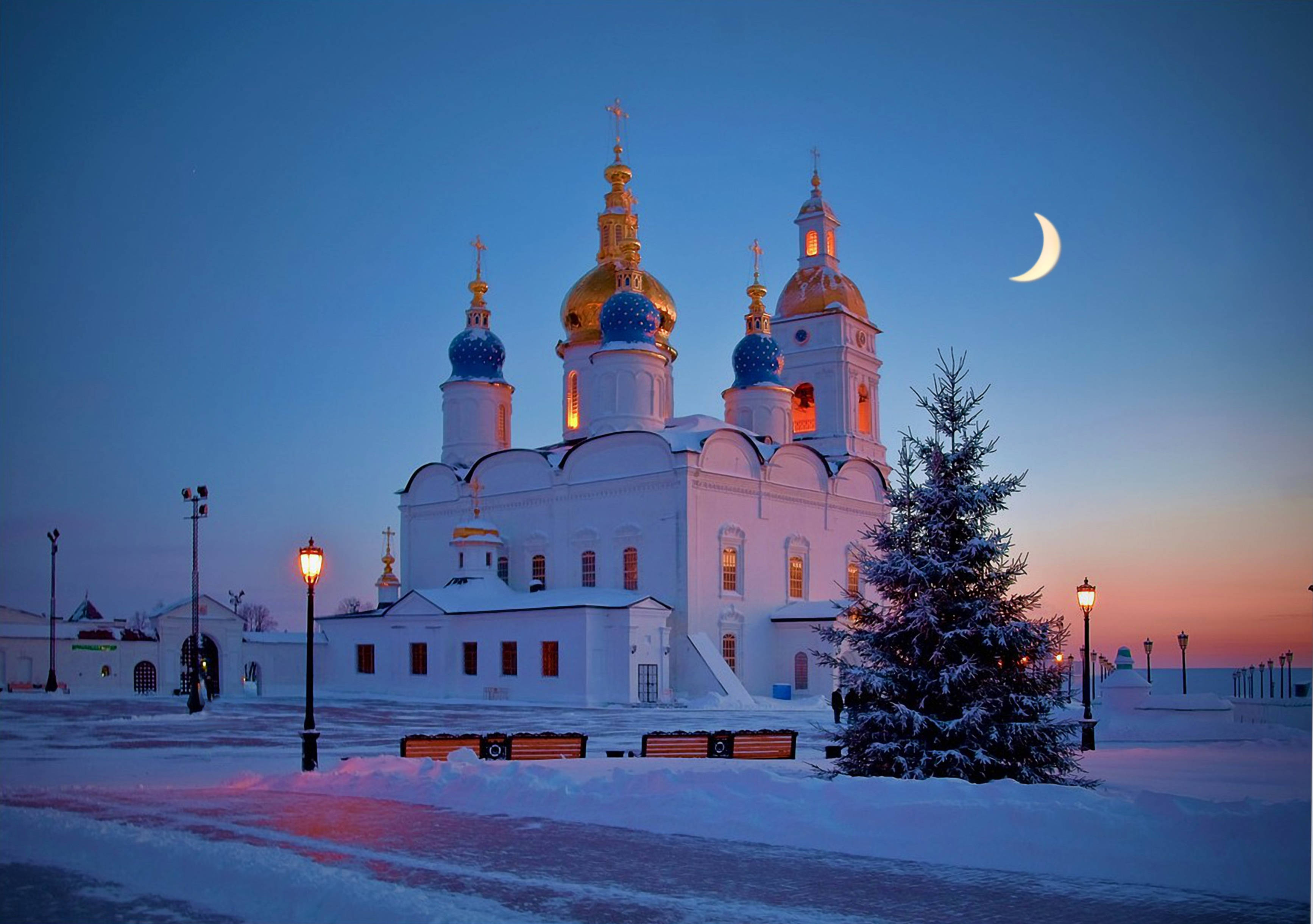 Russia 桌布 壁紙 — 一座被雪覆蓋的東正教教堂，金色圓頂在帶有新月黃昏天空下溫暖地發光。