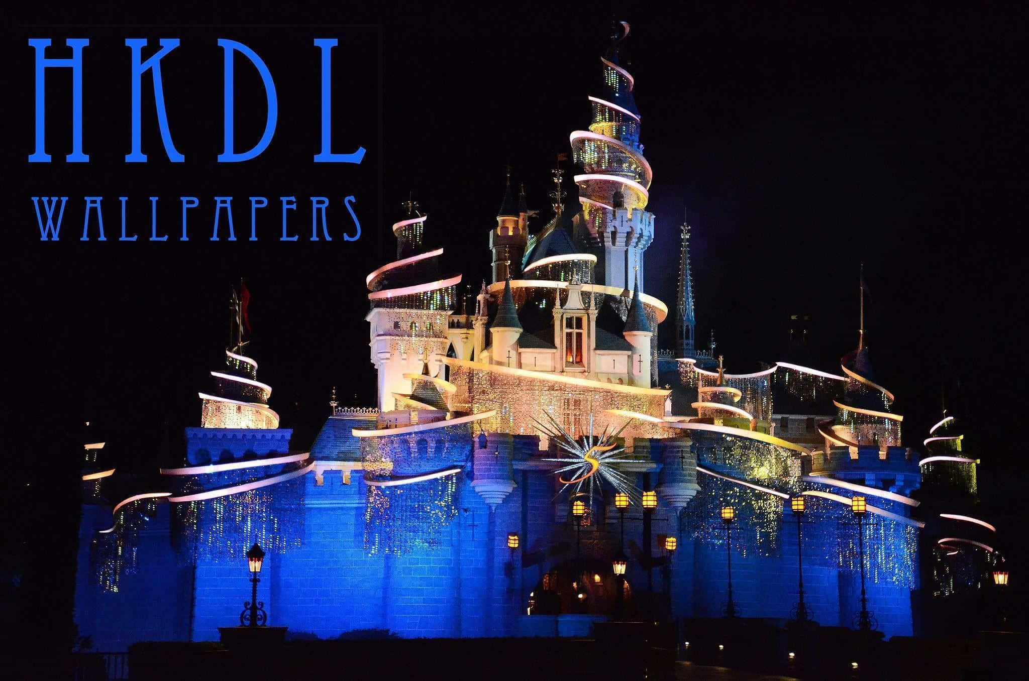 Disneyland 桌布 壁紙 — 一座雄偉的城堡在漆黑的夜空中被鮮豔的藍色和金色燈光照亮。