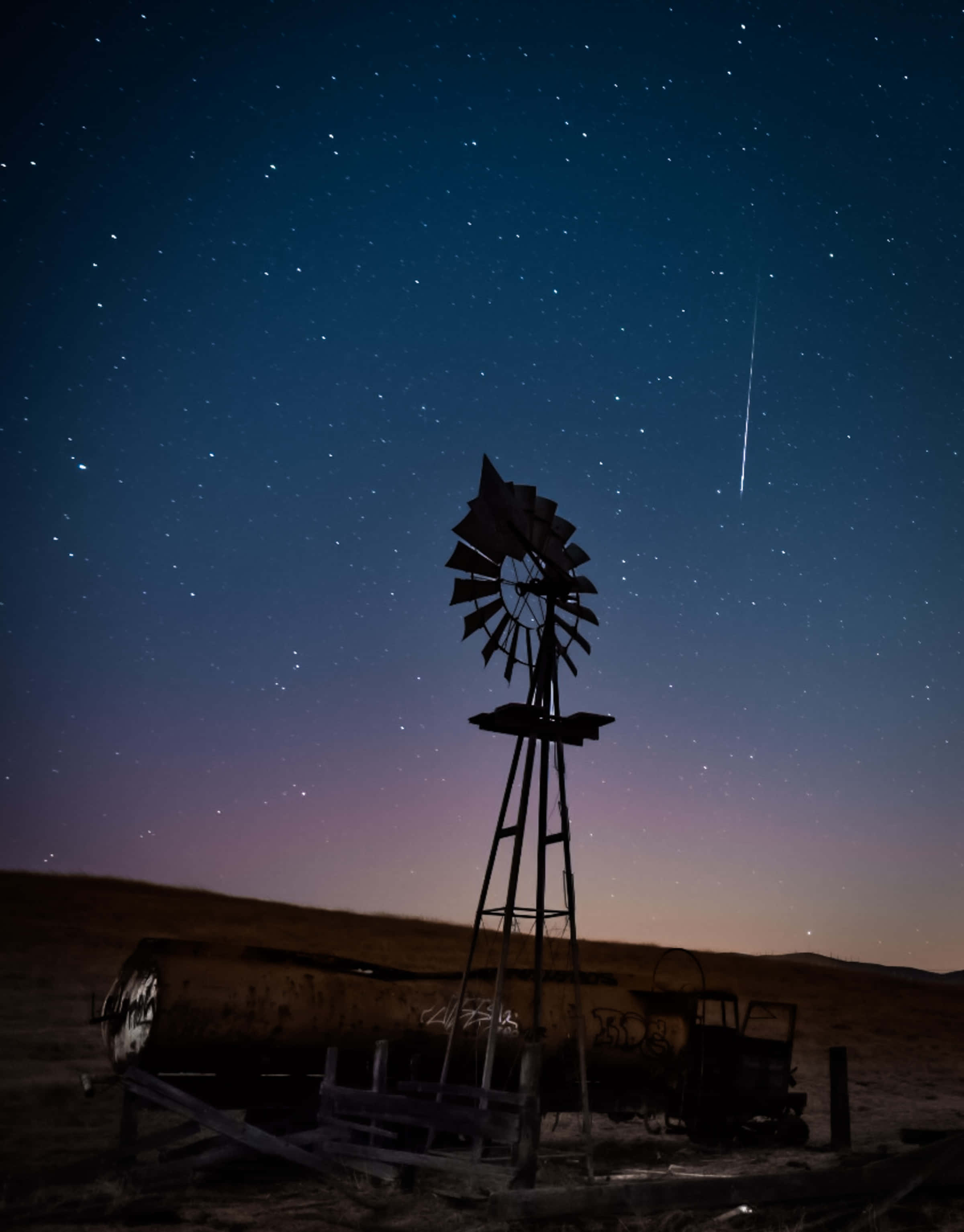 meteor 桌布 壁紙 — 一座風化的風車在繁星點點的夜空下呈現剪影，一顆明亮的流星劃過天際。