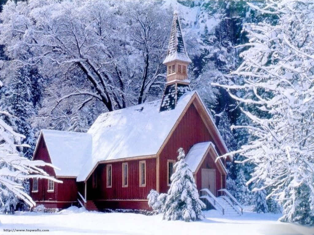 Winter Scene 桌布 壁紙 — 一座鮮紅色的木造教堂，頂著積雪的尖塔，靜靜矗立在白雪覆蓋的冬日森林中。
