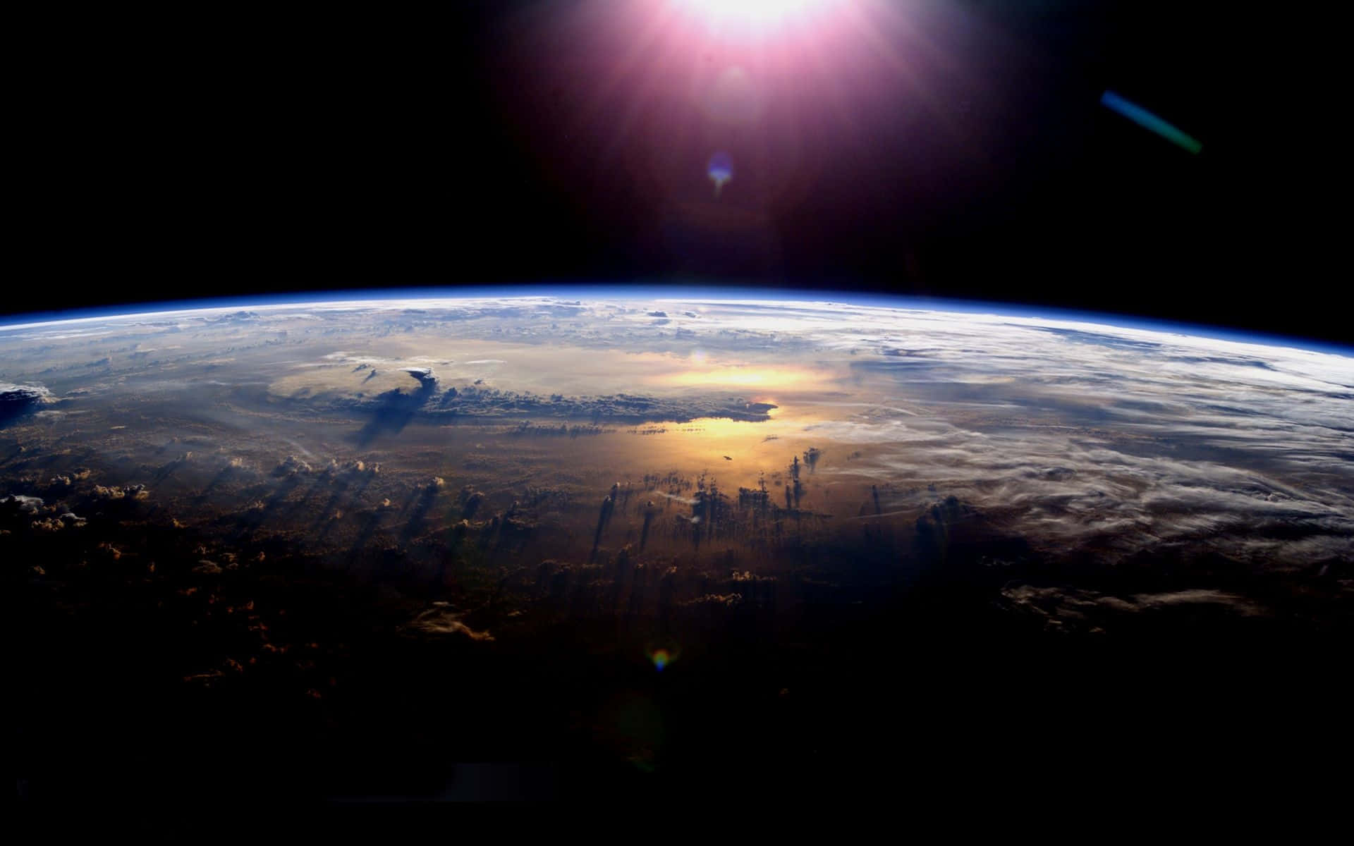 從軌道觀看行星地球，太陽在地平線上閃耀。